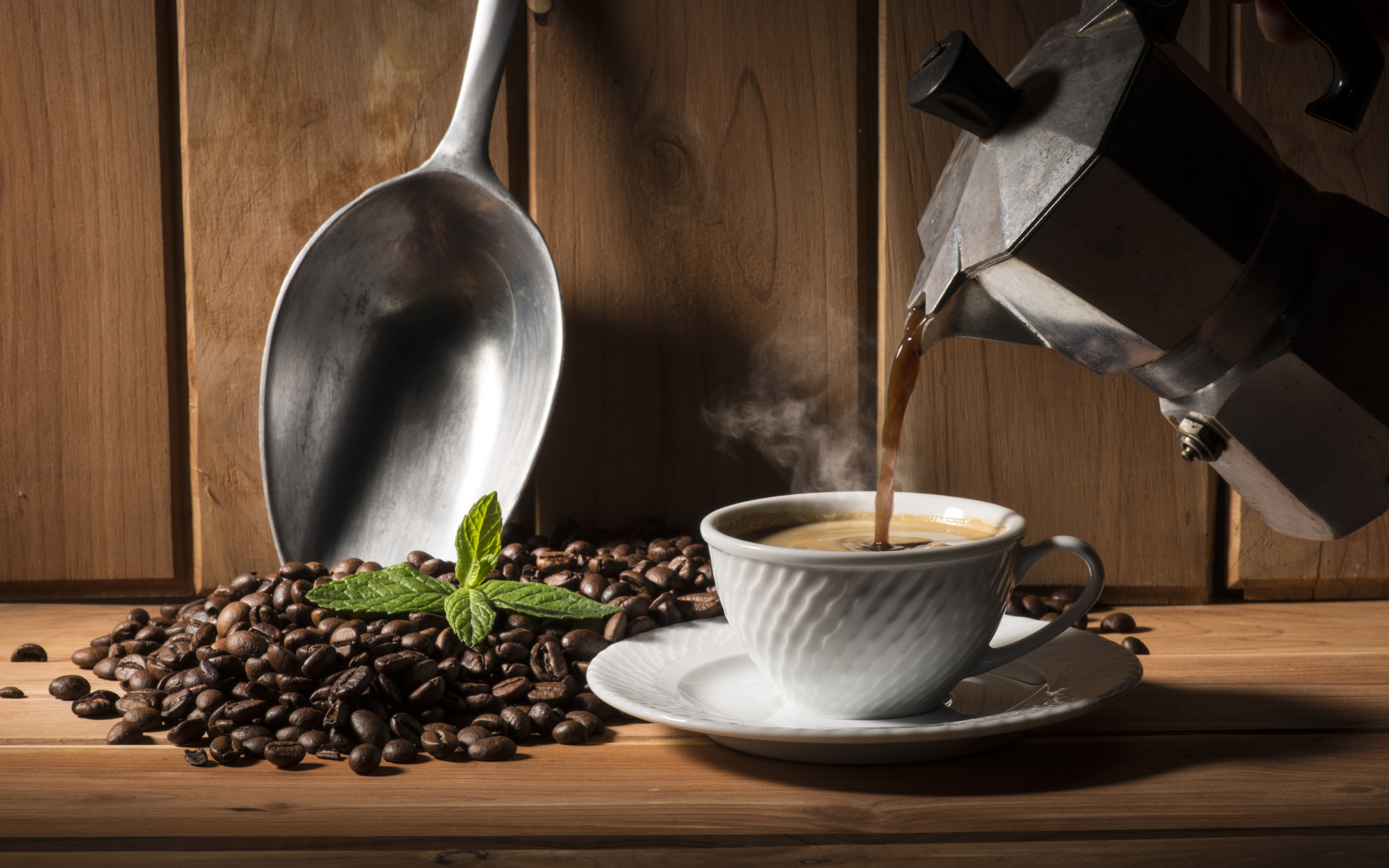Горячий кофе наливают в чашку на столе с кофейными зернами