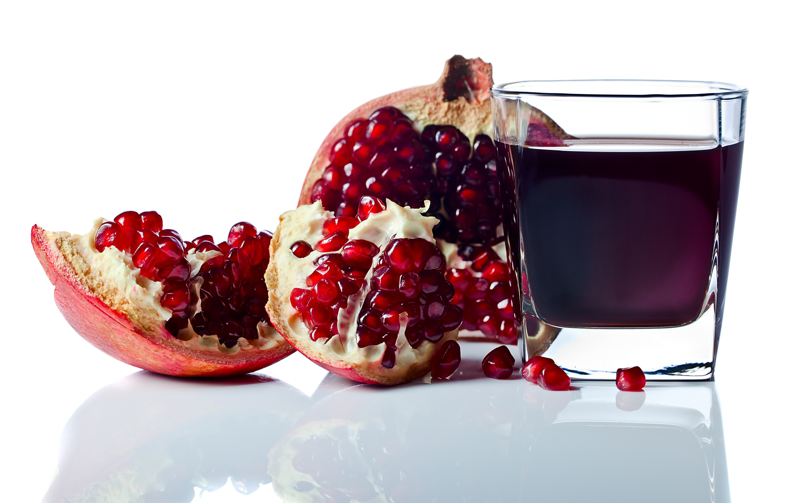 Гранатовый сок с плодом граната на белом фоне