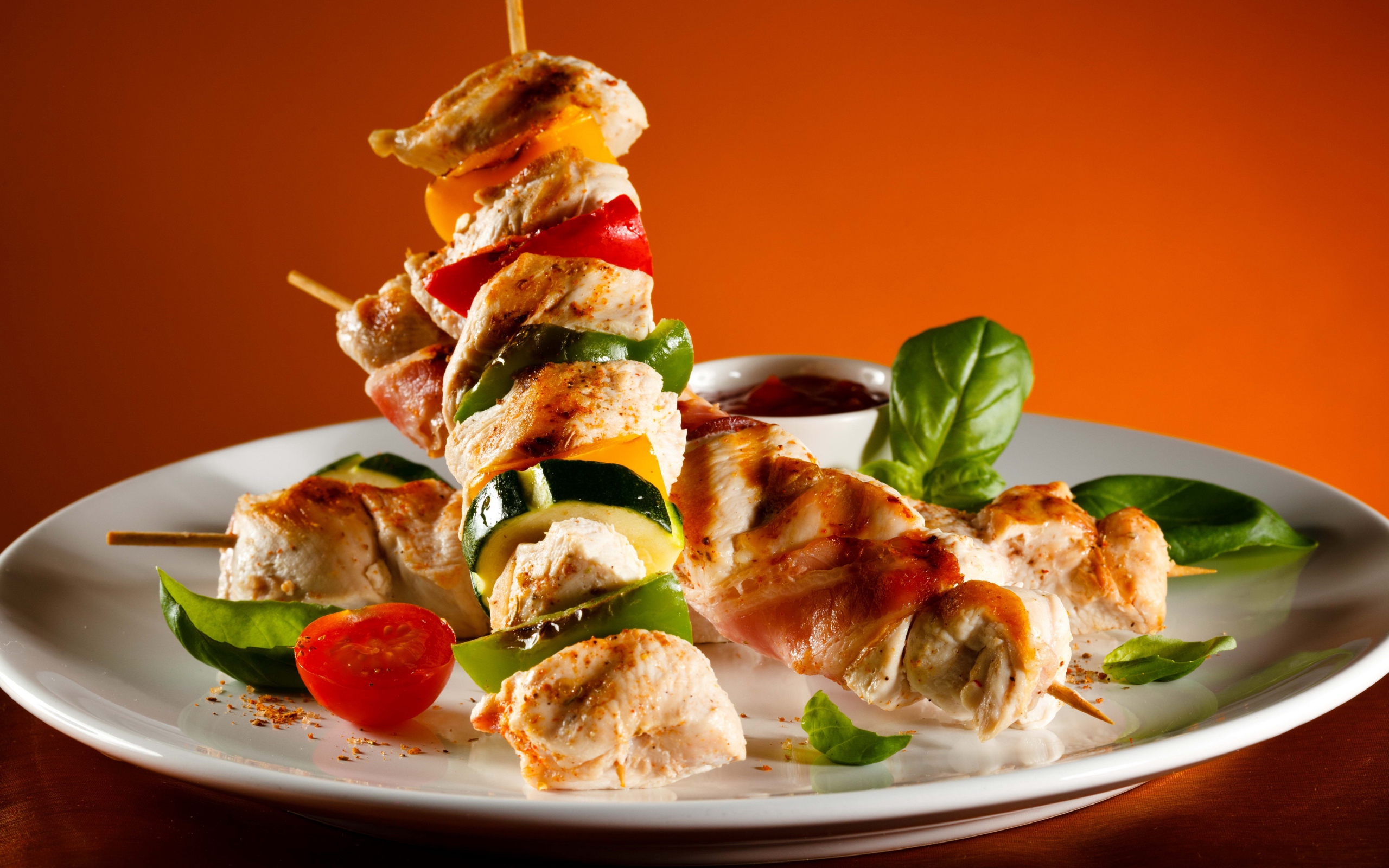 Куриные шашлыки с овощами на белой тарелке