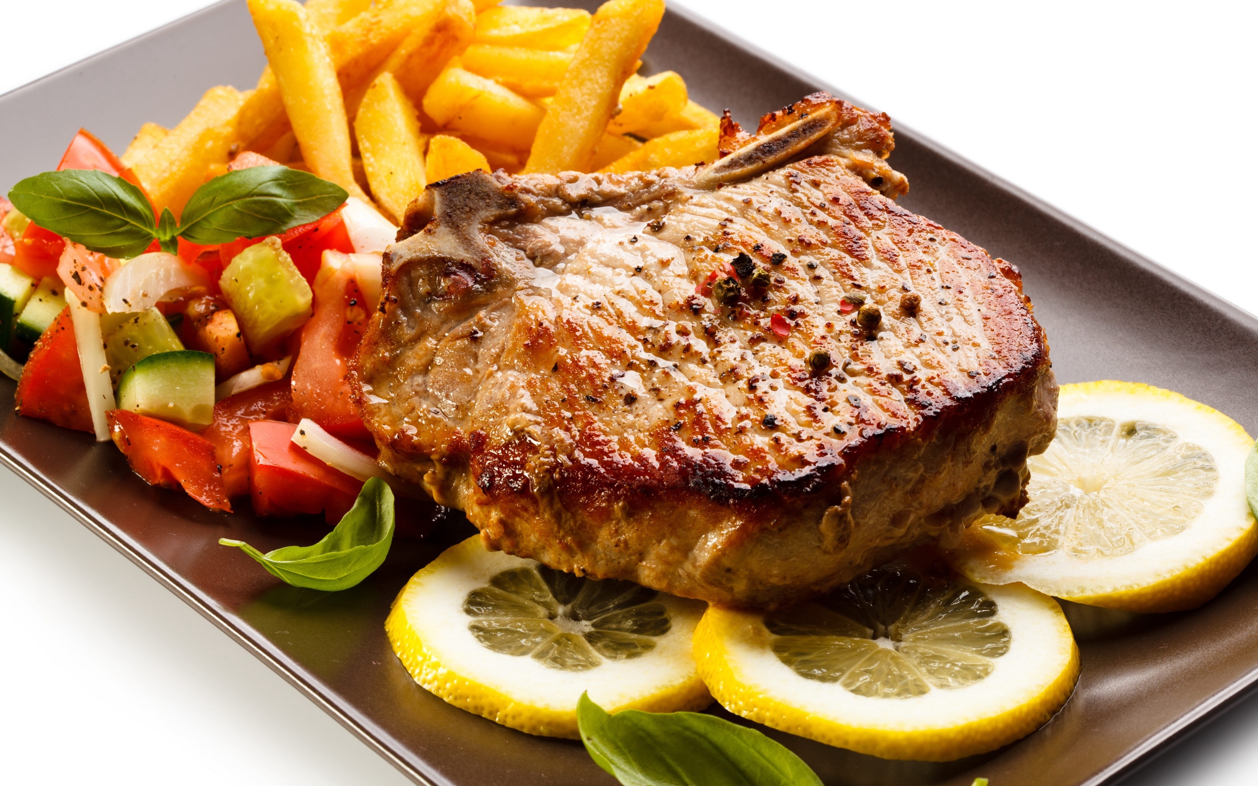Мясо с картофелем  фри, салатом и кусочками лимона