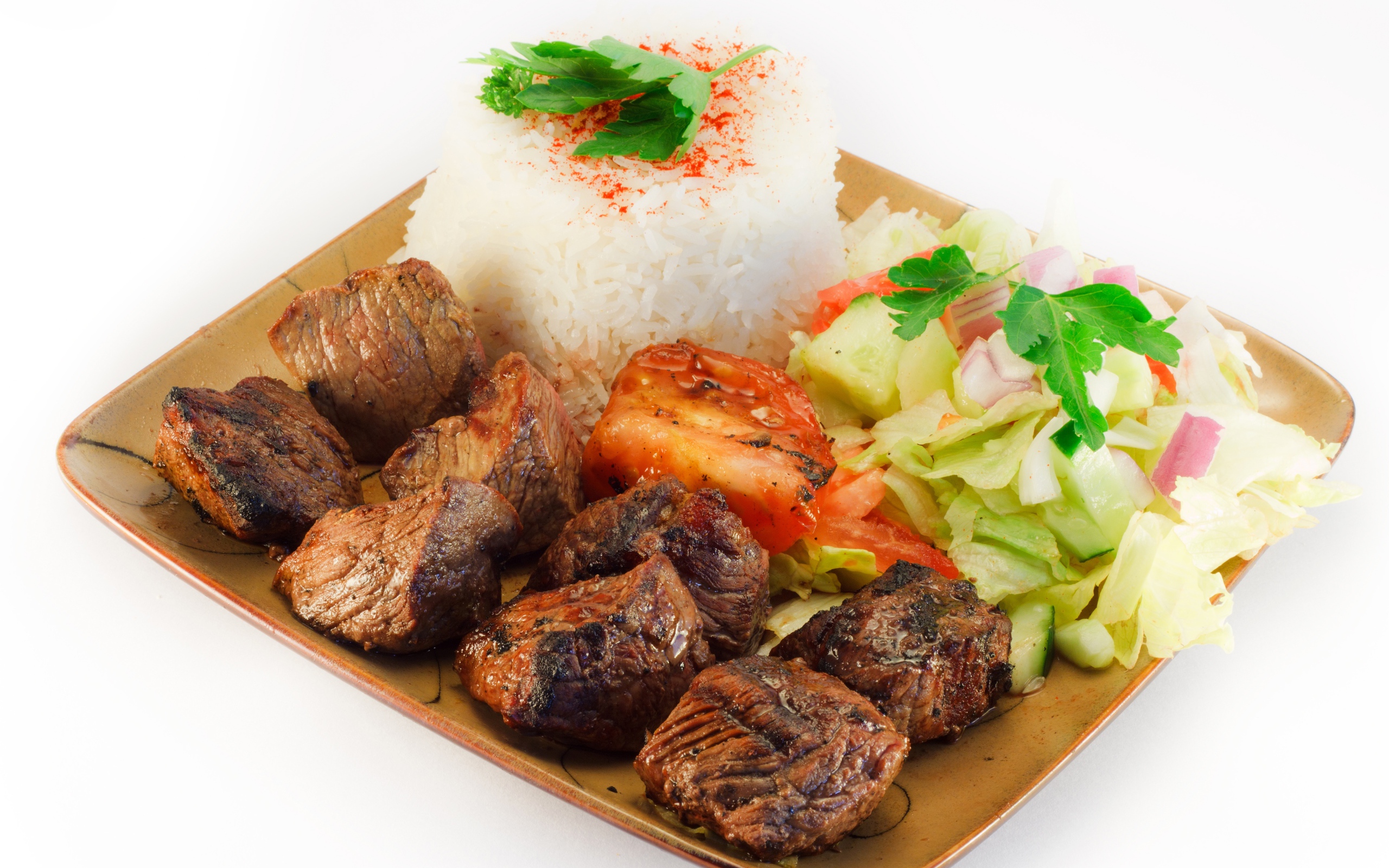 Шашлык с рисом и овощами в тарелке на белом фоне
