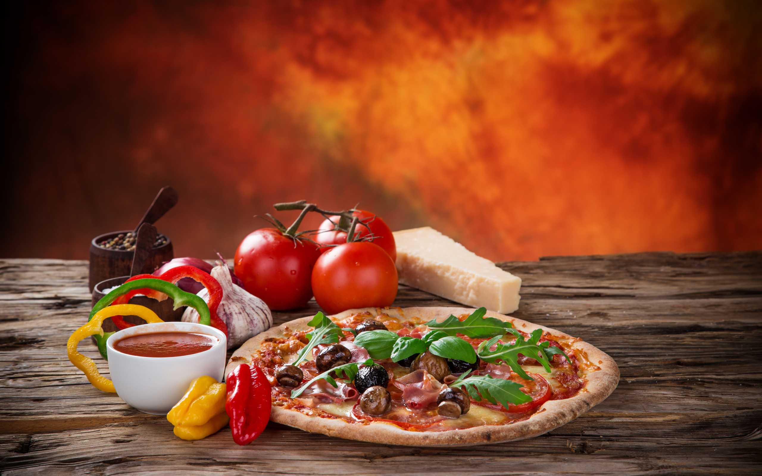 Пицца с колбасой и грибами на столе с соусом и овощами 