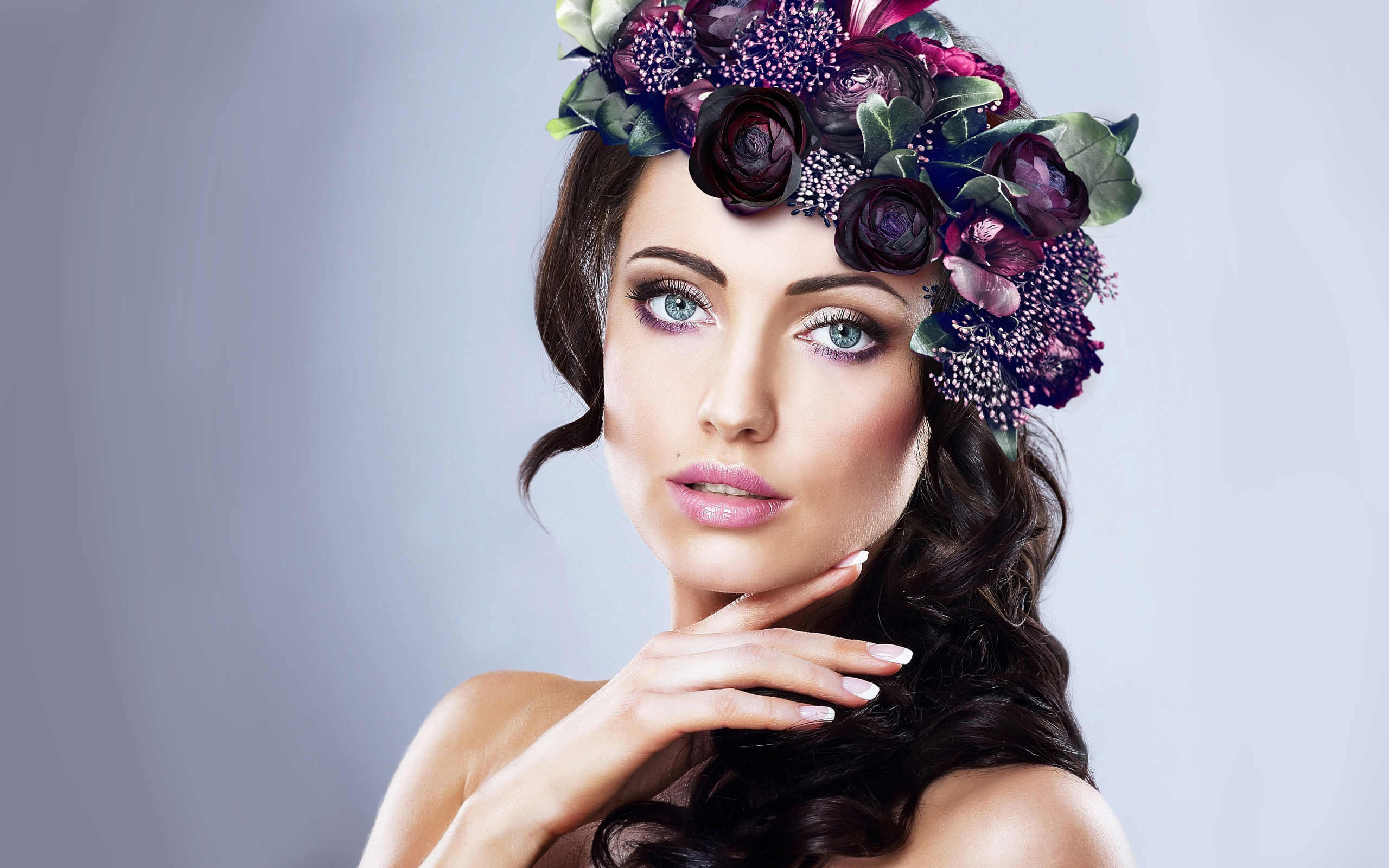 Красивая голубоглазая девушка с венком на голове на сером фоне