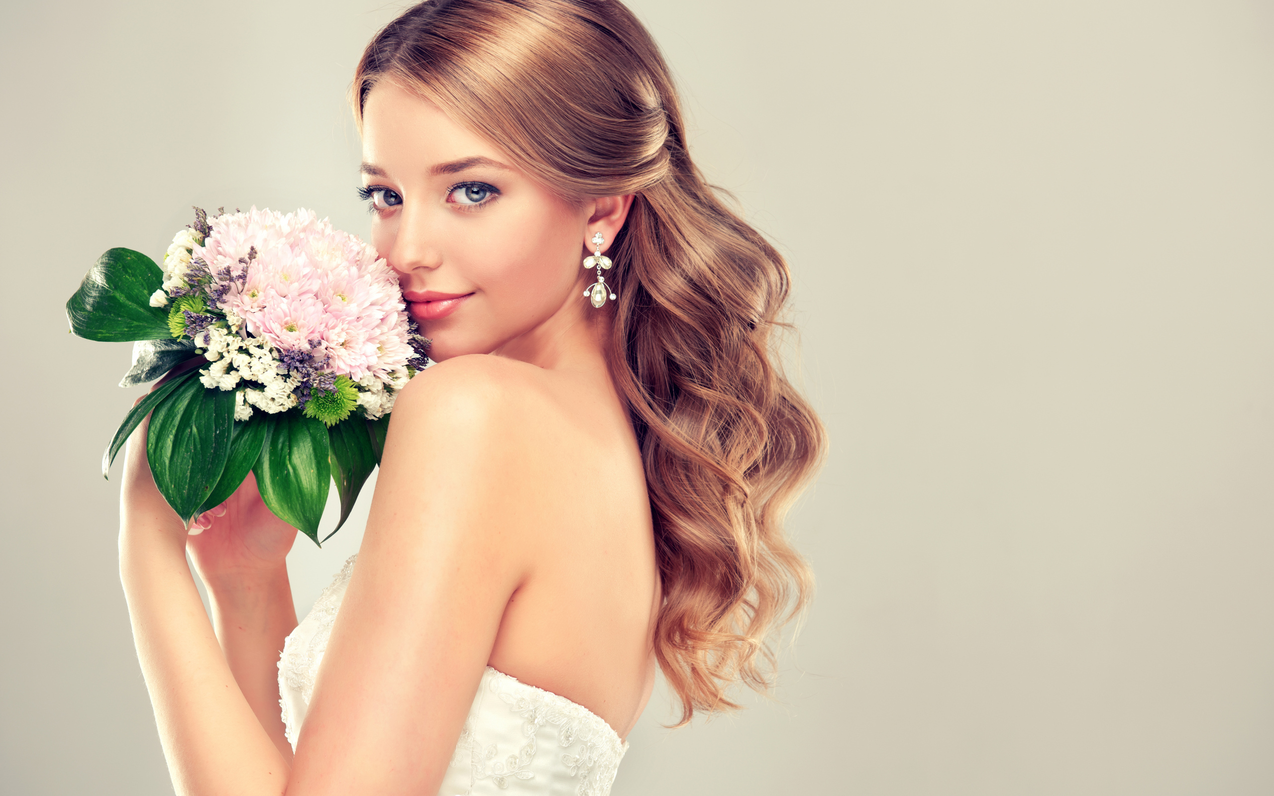 Красивая девушка невеста с букетом цветов на сером фоне