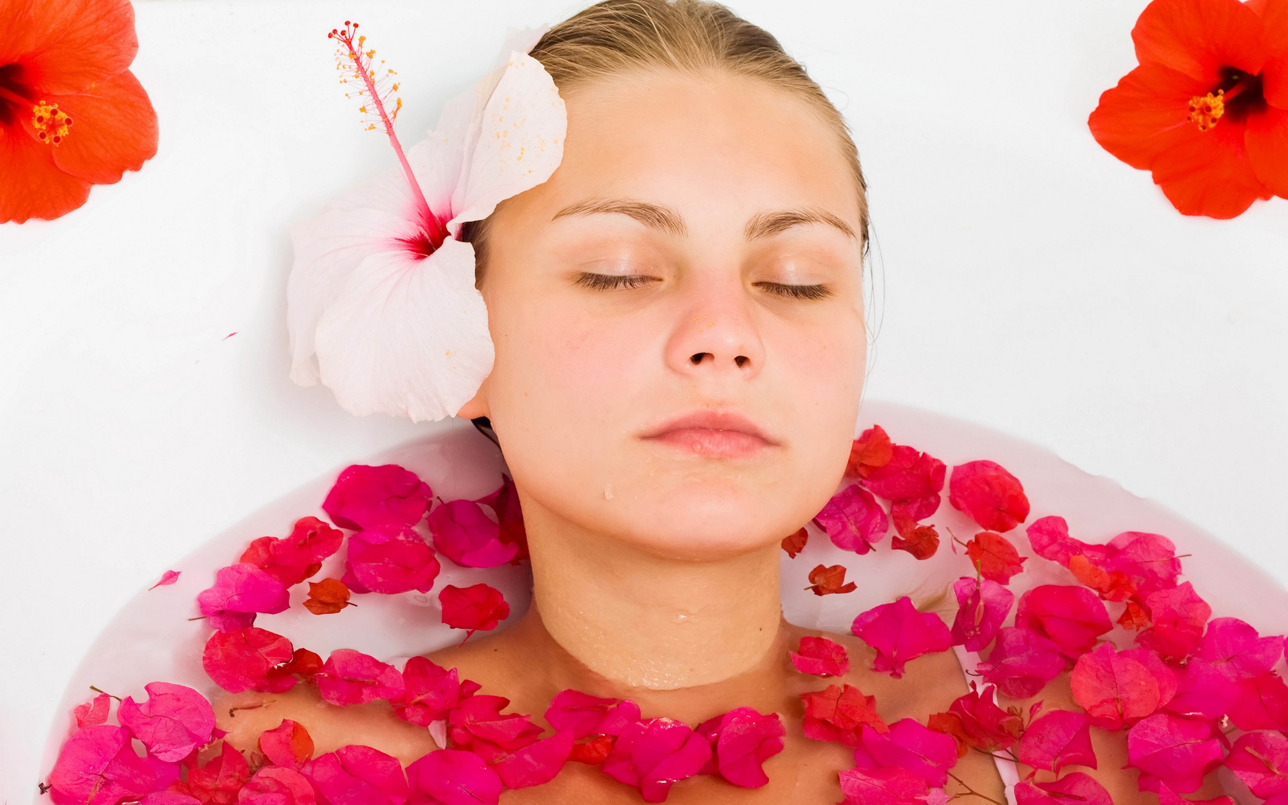 Красивая девушка в ванной с лепестками розы 