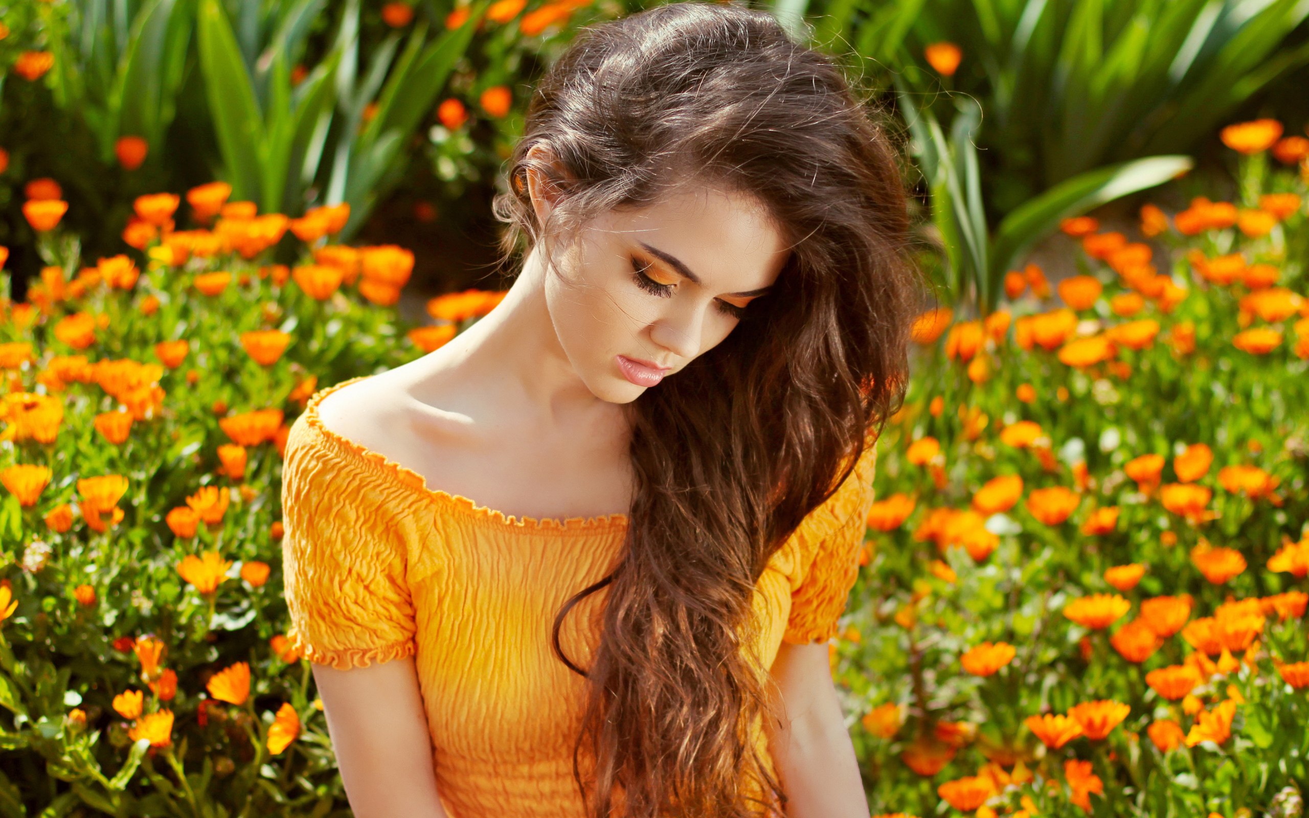 Красивая девушка у цветов календулы