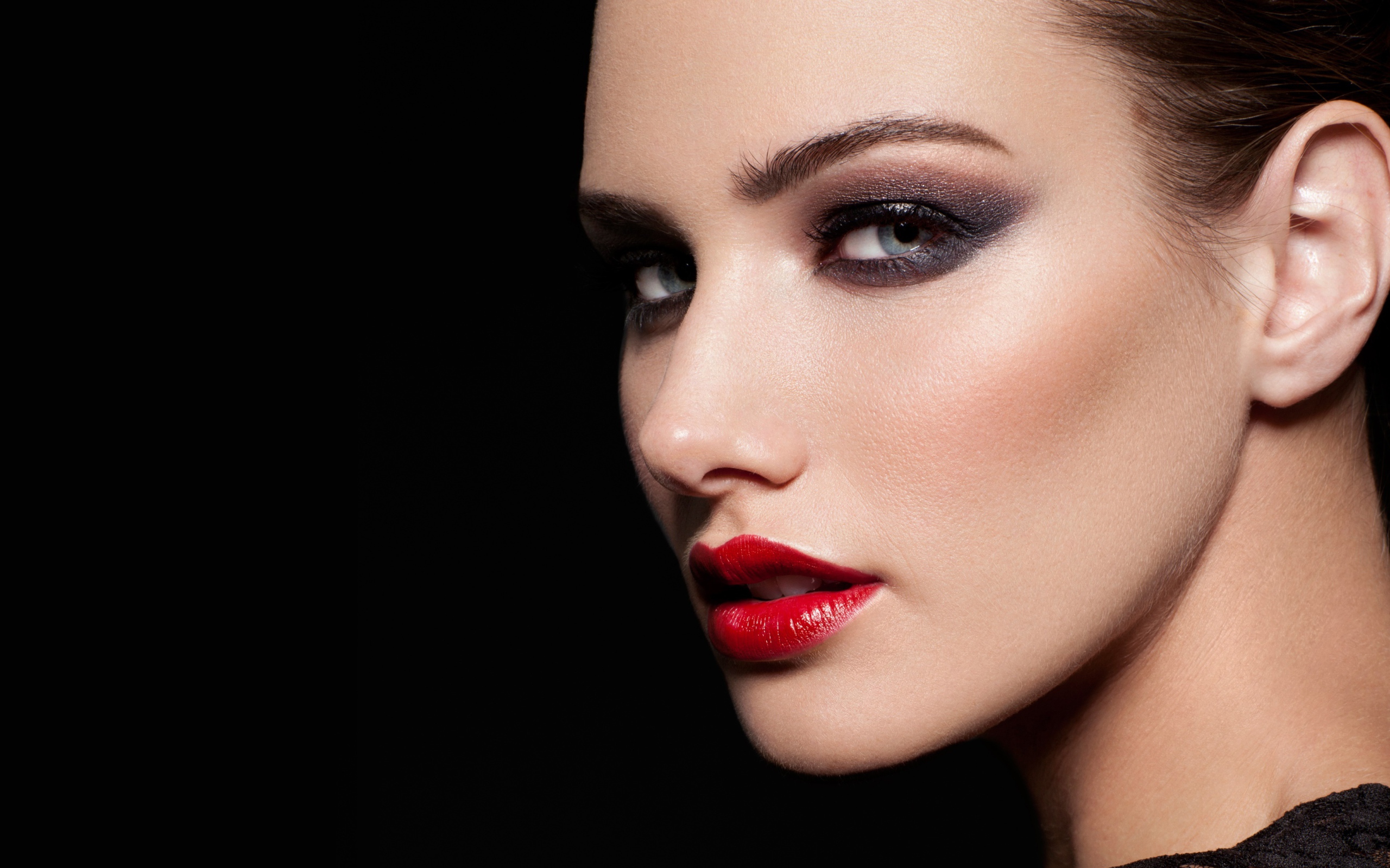 Красивая девушка с яркой помадой на губах на черном фоне