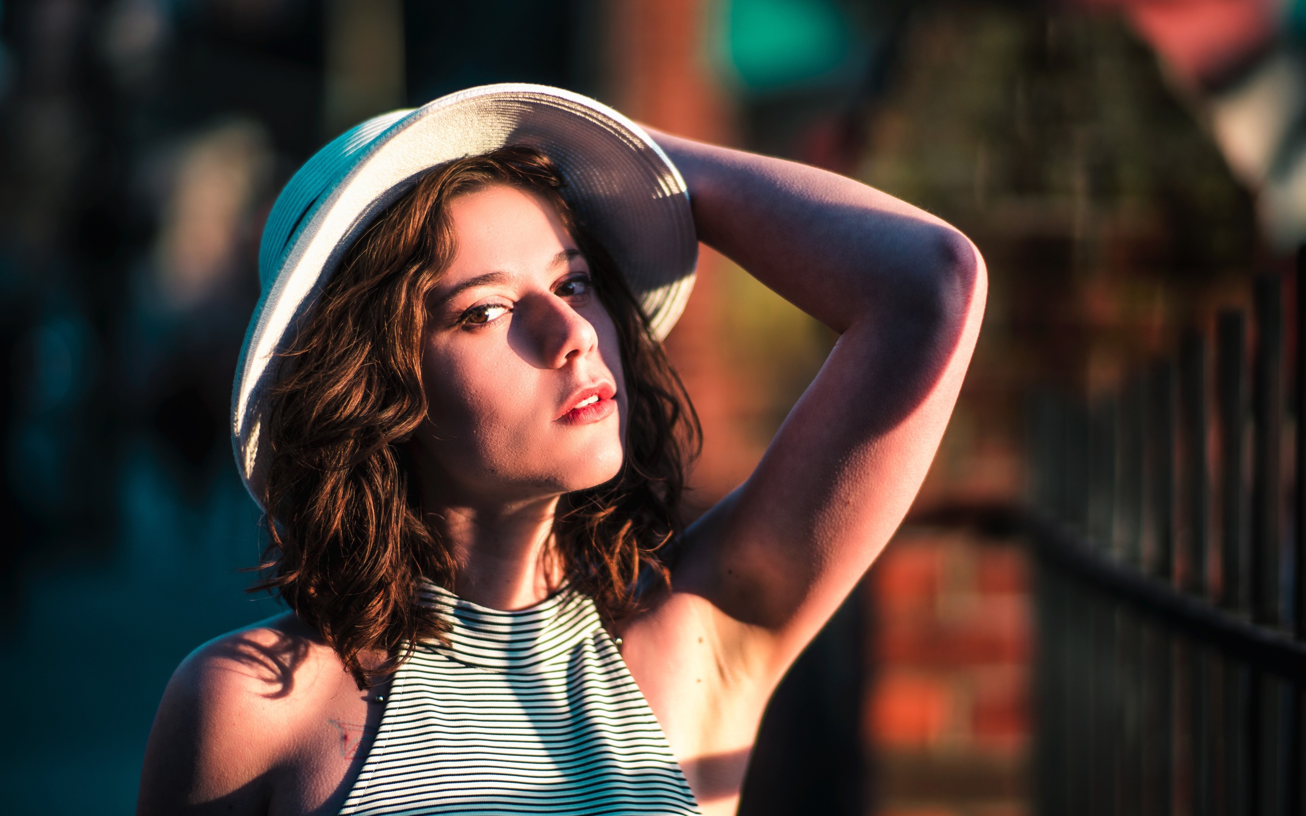 Красивая молодая девушка в белой шляпе в свете солнца