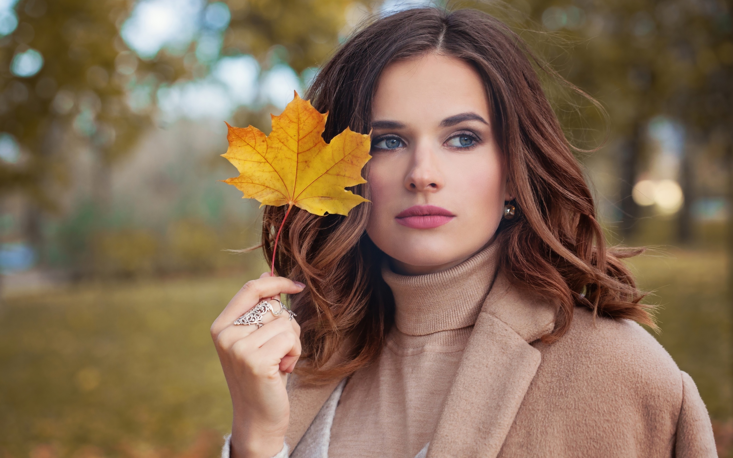 Красивая молодая девушка шатенка с желтым листом в руке