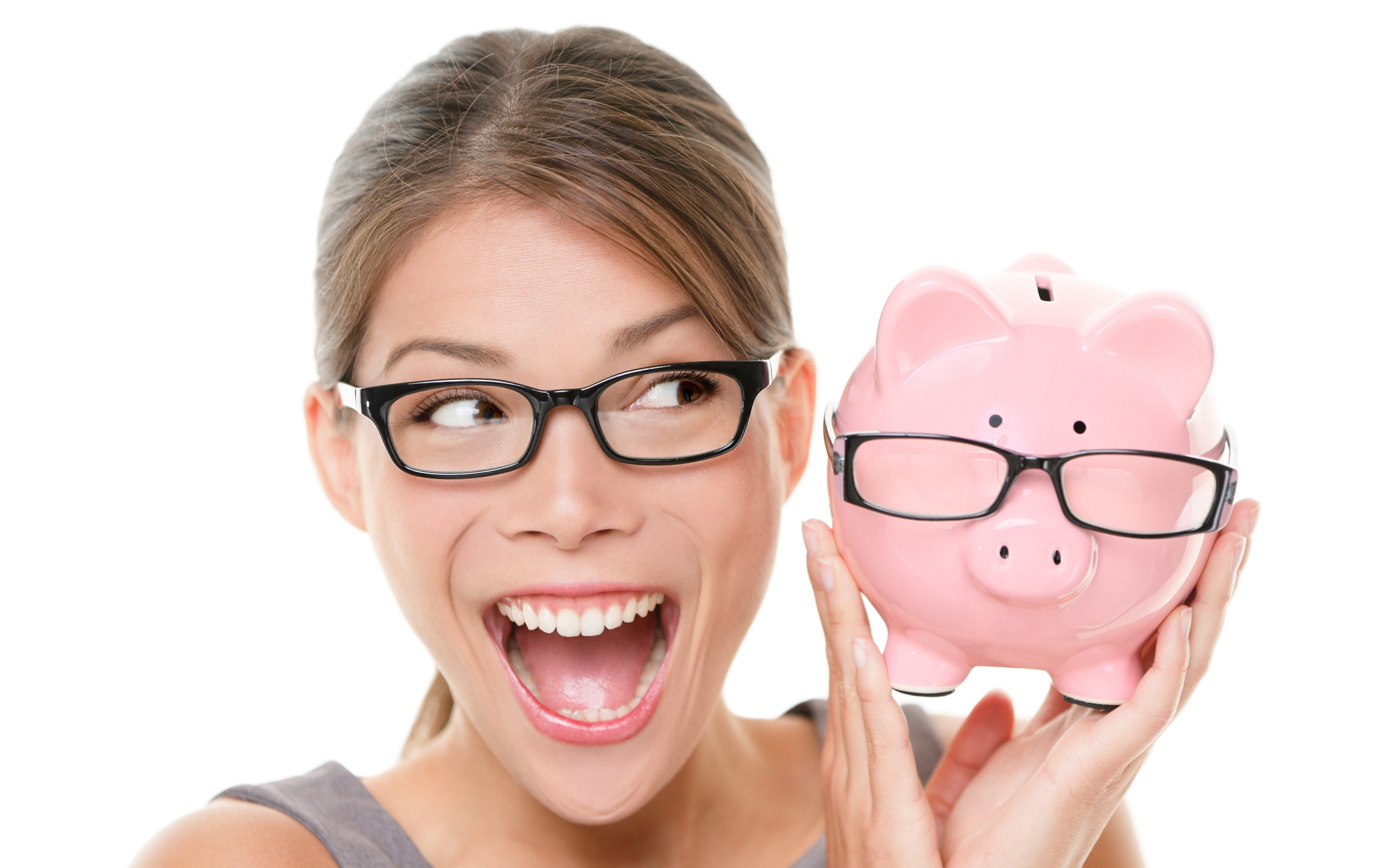 Веселая девушка в очках с копилкой в руках на белом фоне