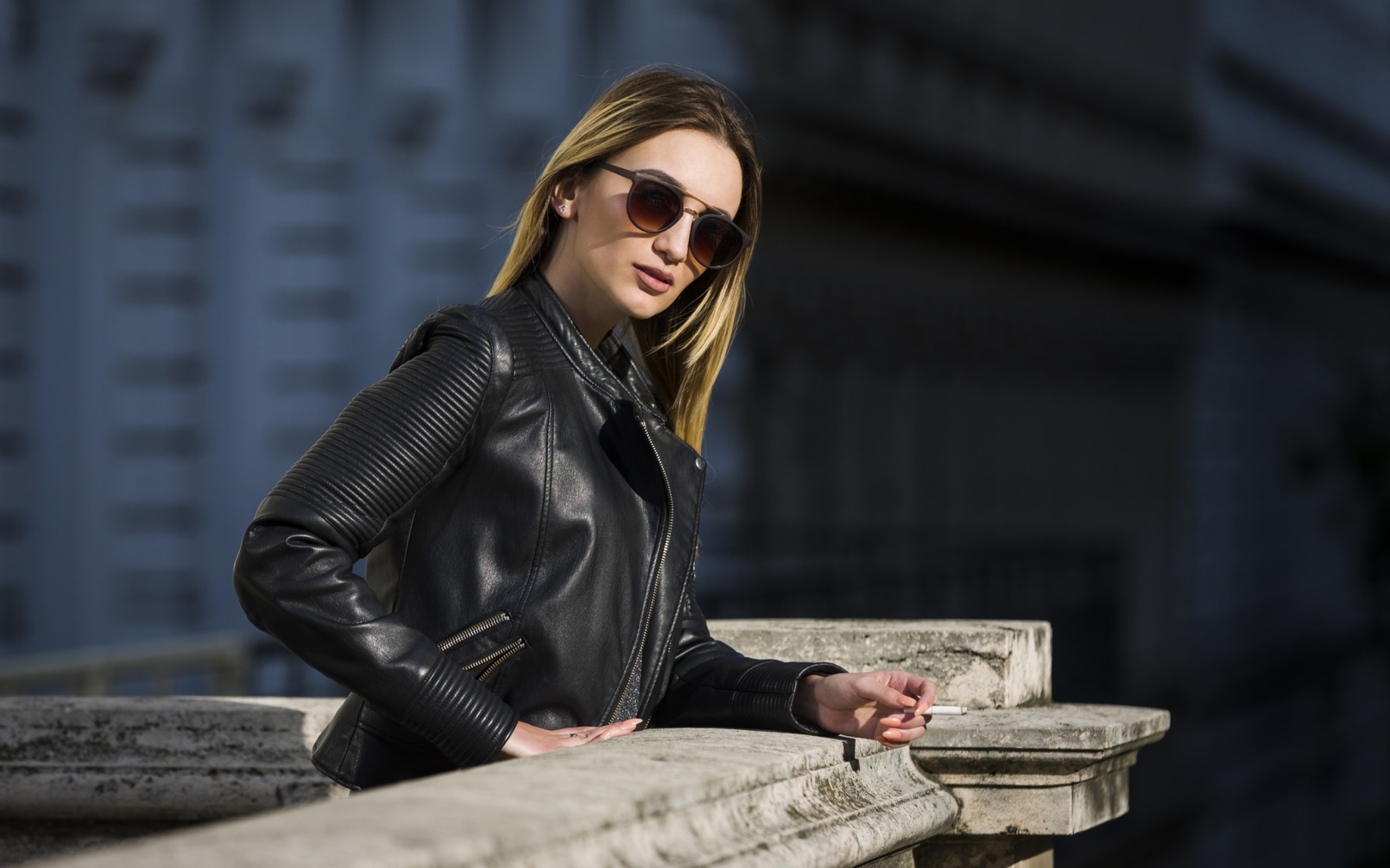 Дерзкая девушка в черной кожаной куртке и очках