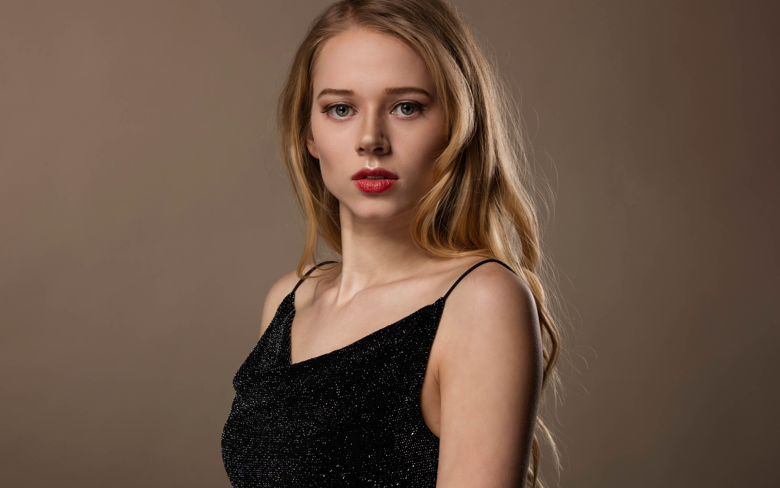 Нежная девушка модель в черном платье на сером фоне