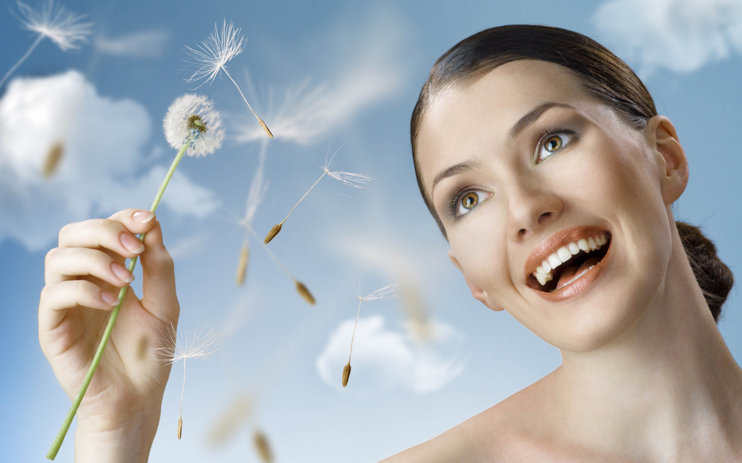 Счастливая девушка с одуванчиком в руке 