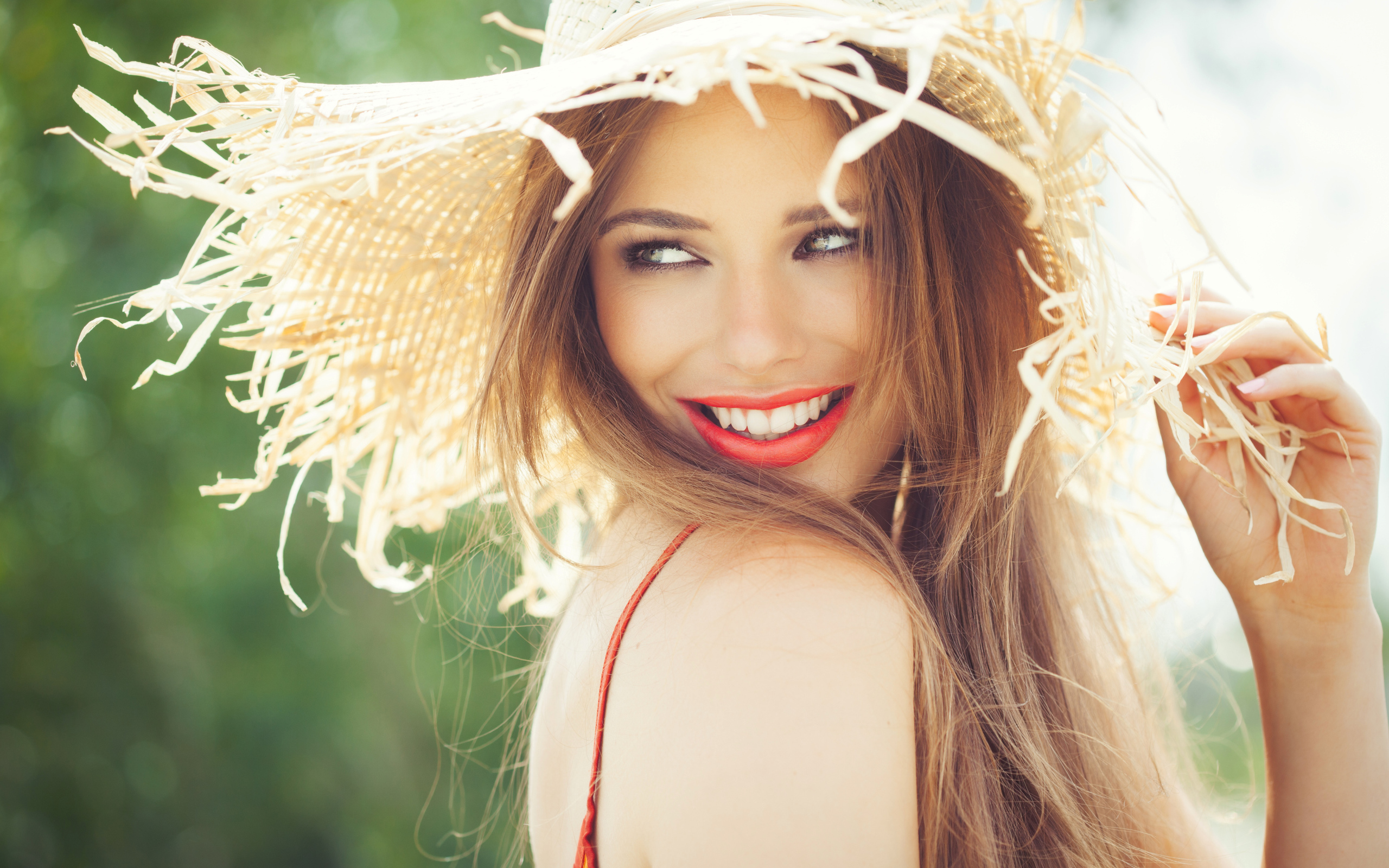 Улыбающаяся девушка в соломенной шляпе летом