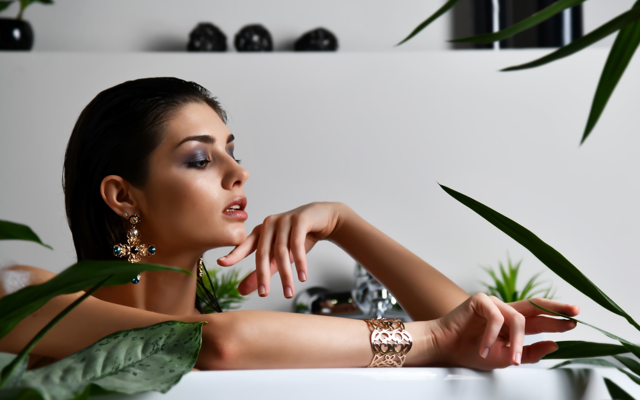 Девушка в дорогих украшения лежит в ванной