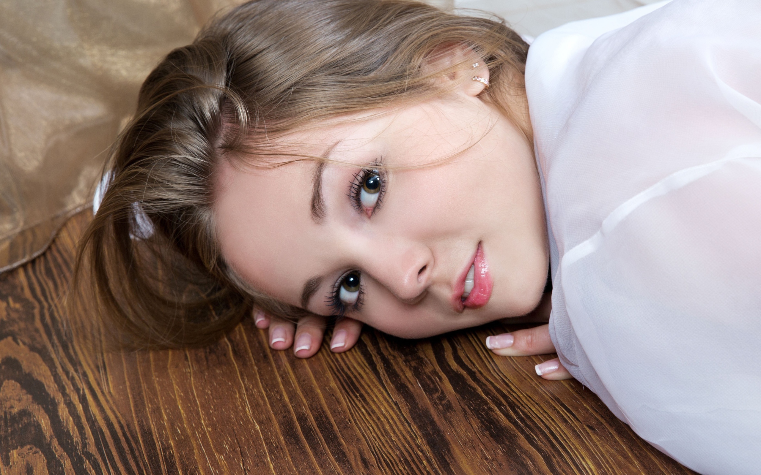 Нежная девушка шатенка лежит на полу