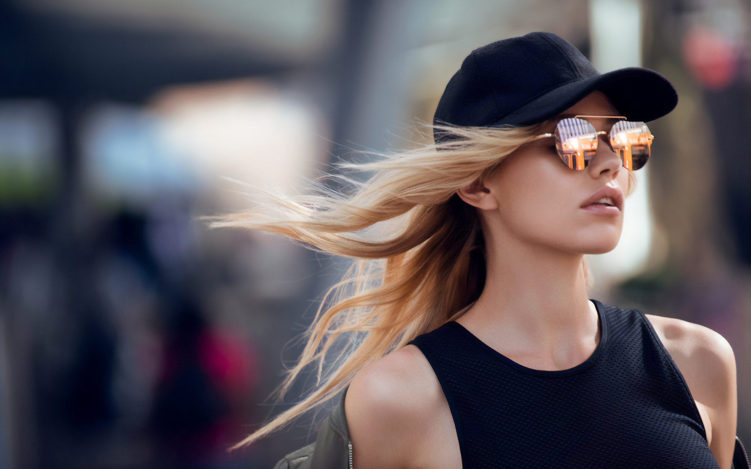 Молодая блондинка в солнечных очках и черной кепке 