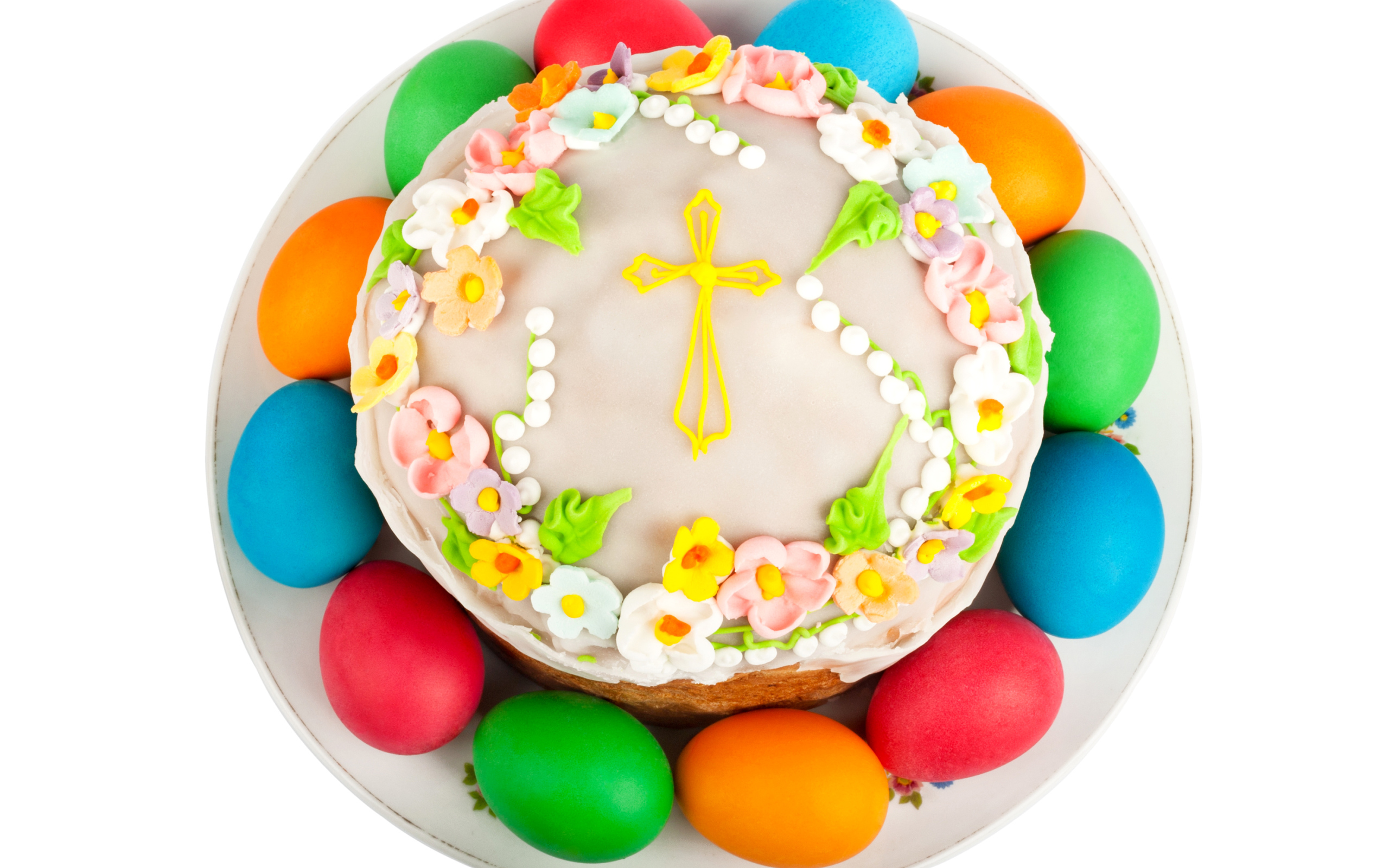 Красивый пасхальный кулич с цветами и разноцветными крашеными яйцами на белом фоне