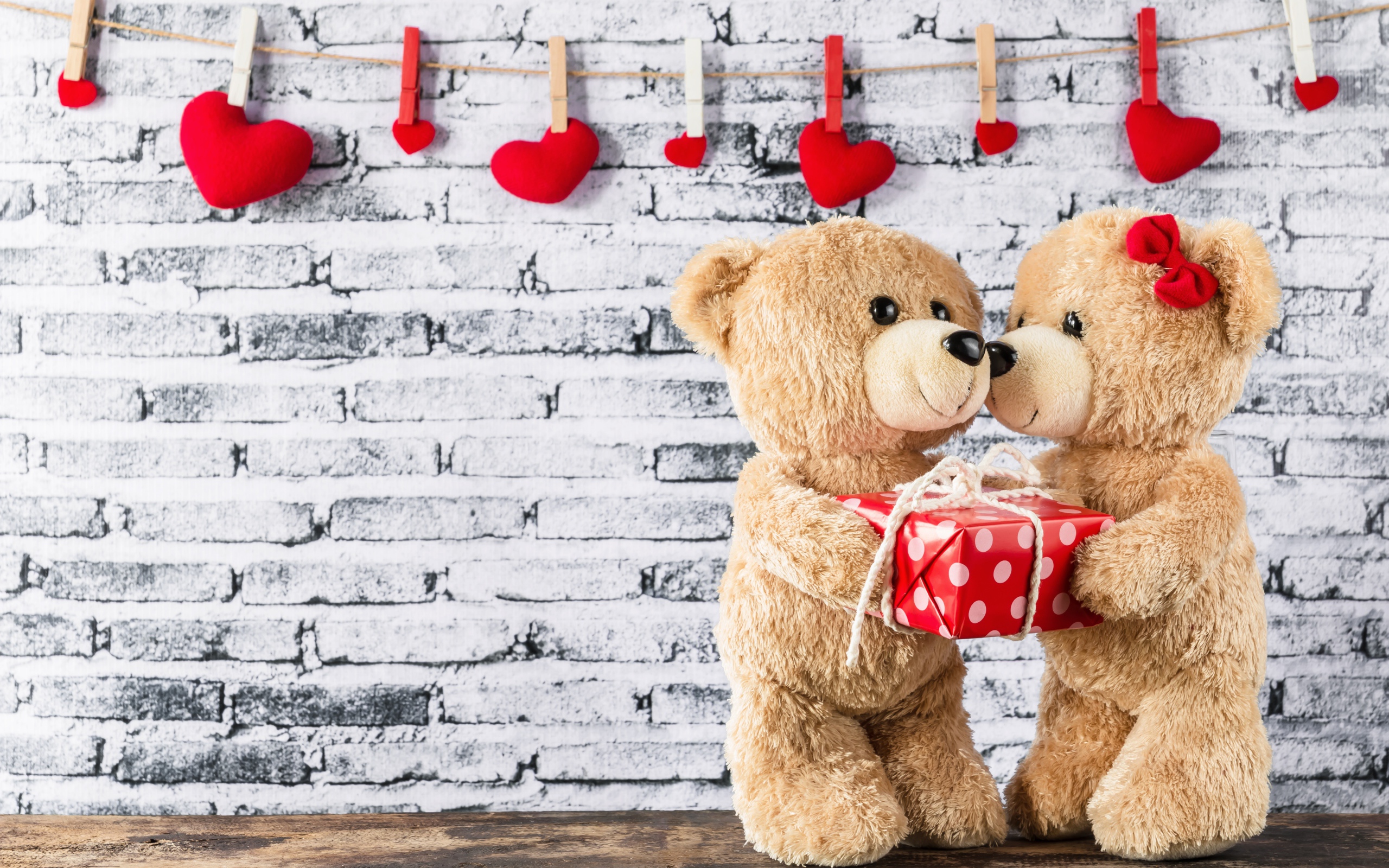 Влюбленные плюшевые мишки на фоне стены с сердечками 