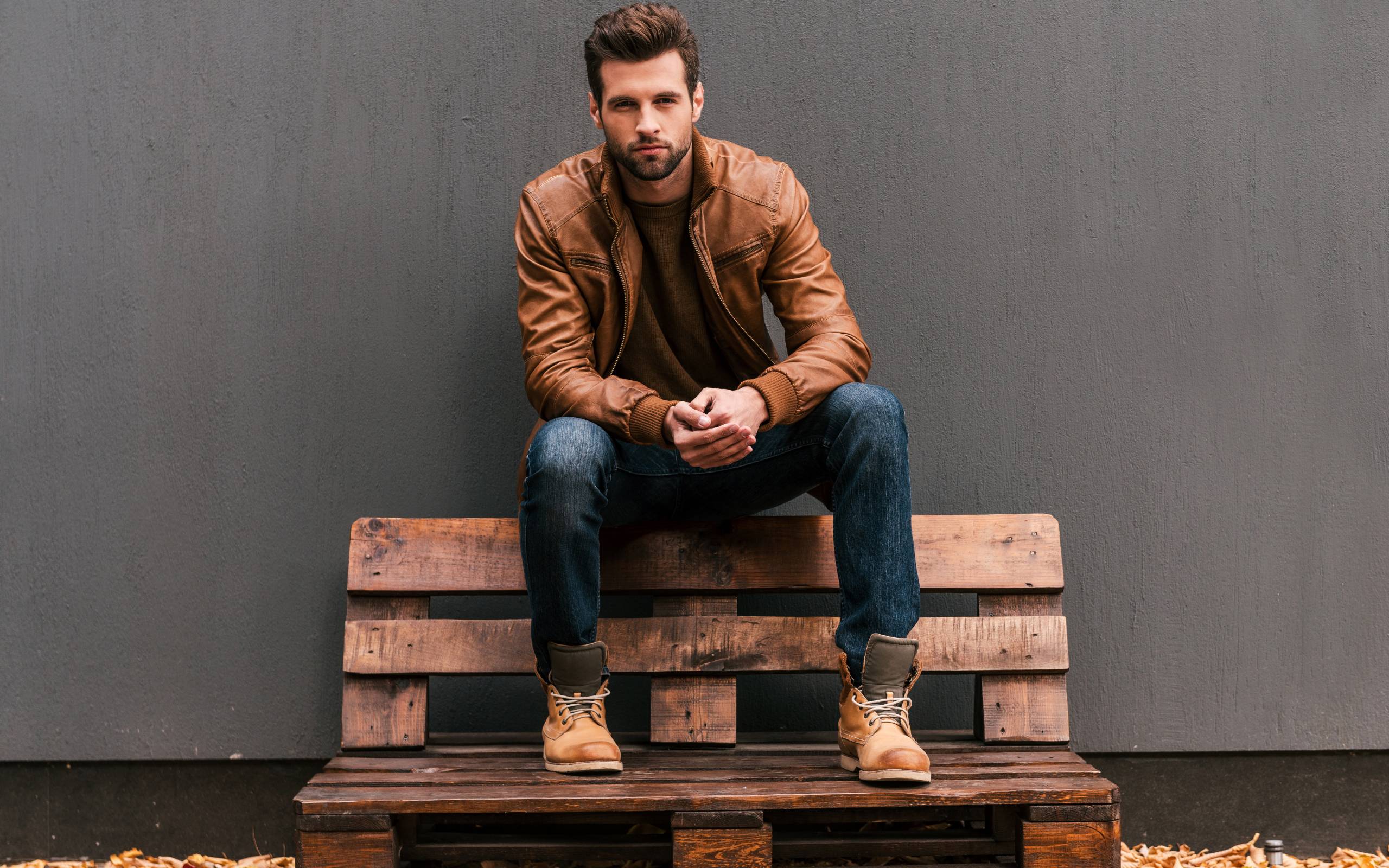 Young handsome man sitting on a wooden bench