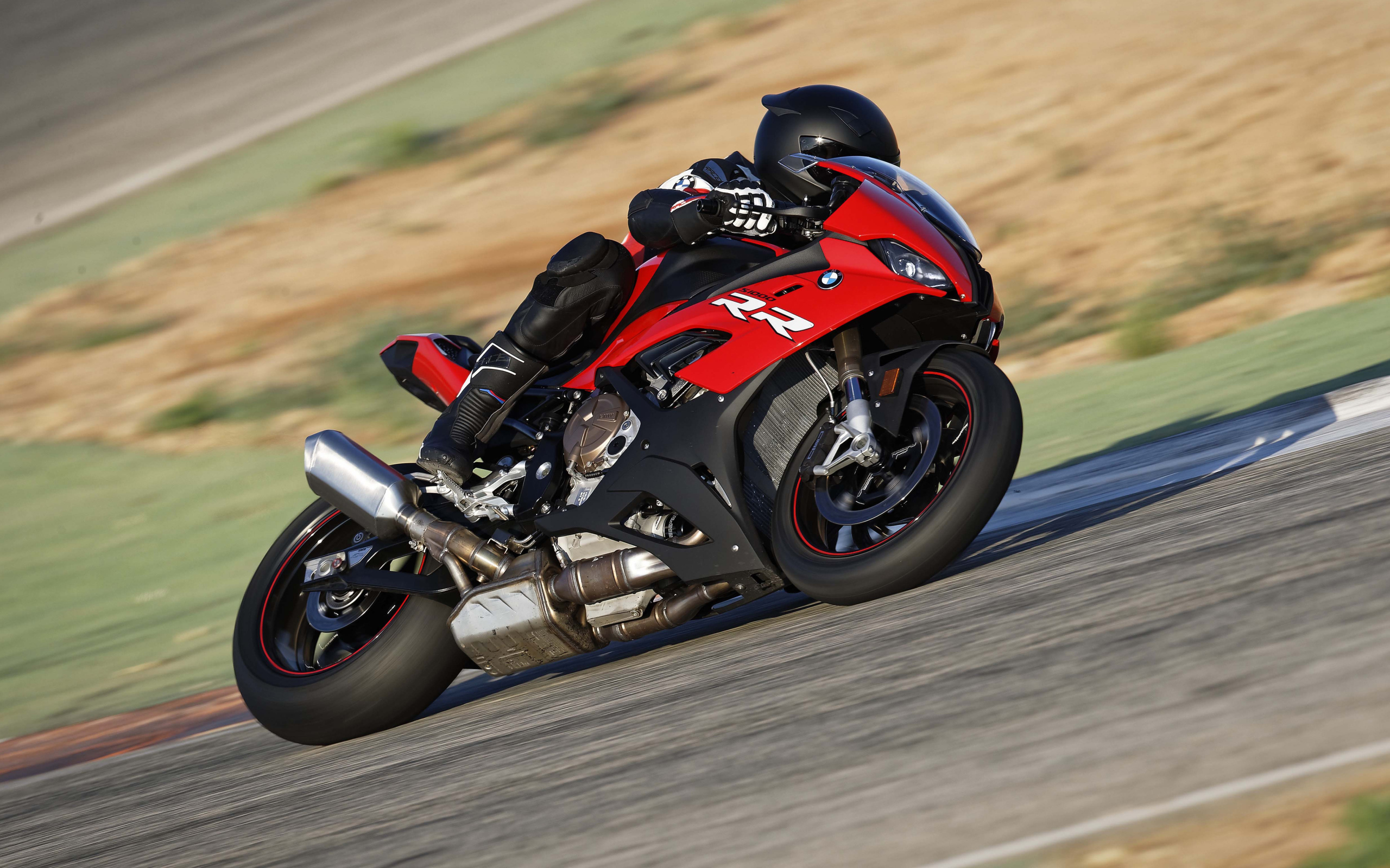 Гонщик на мотоцикле BMW S1000 совершает крутой поворот