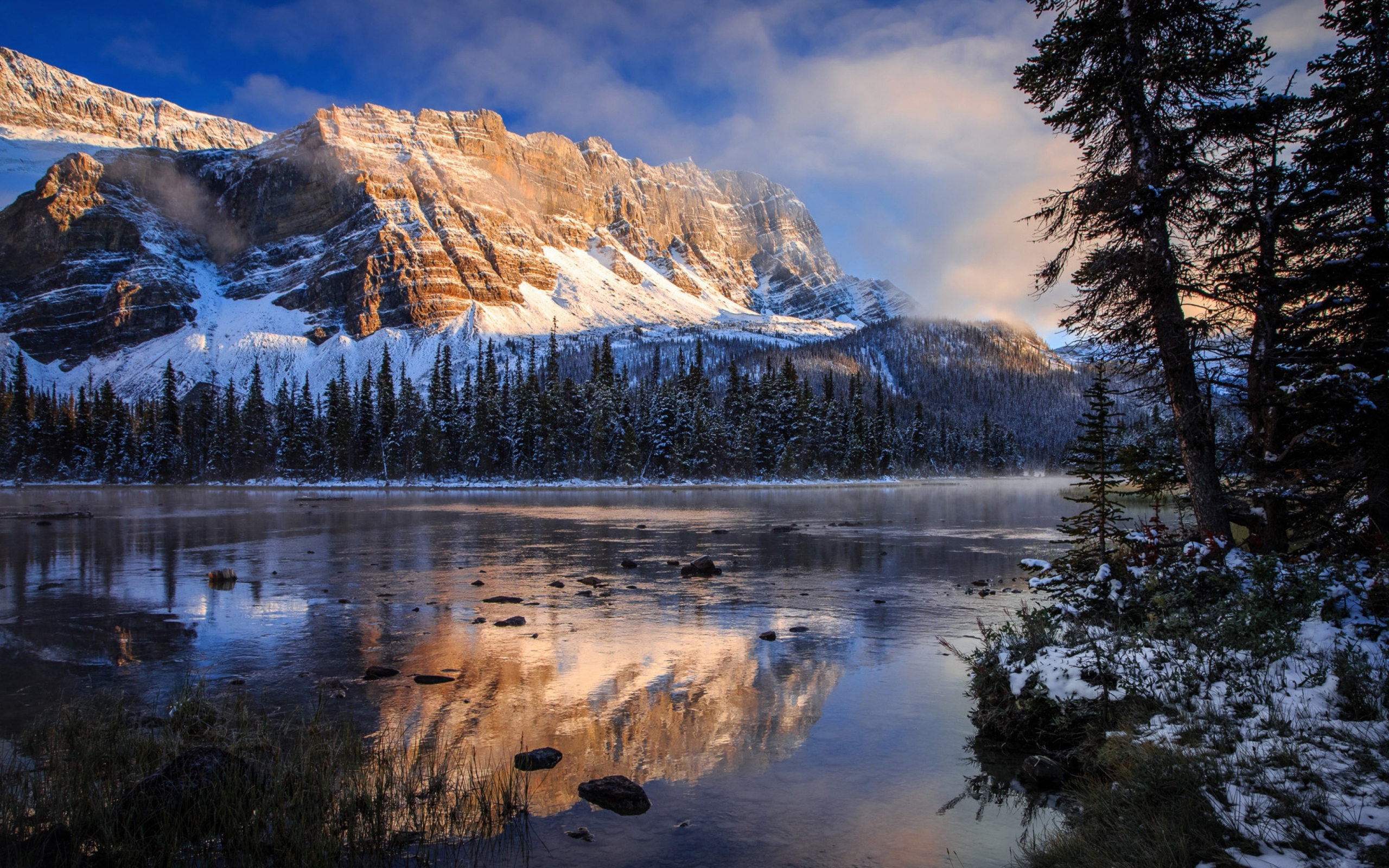 Покрытые снегом горы у заледеневшего озера