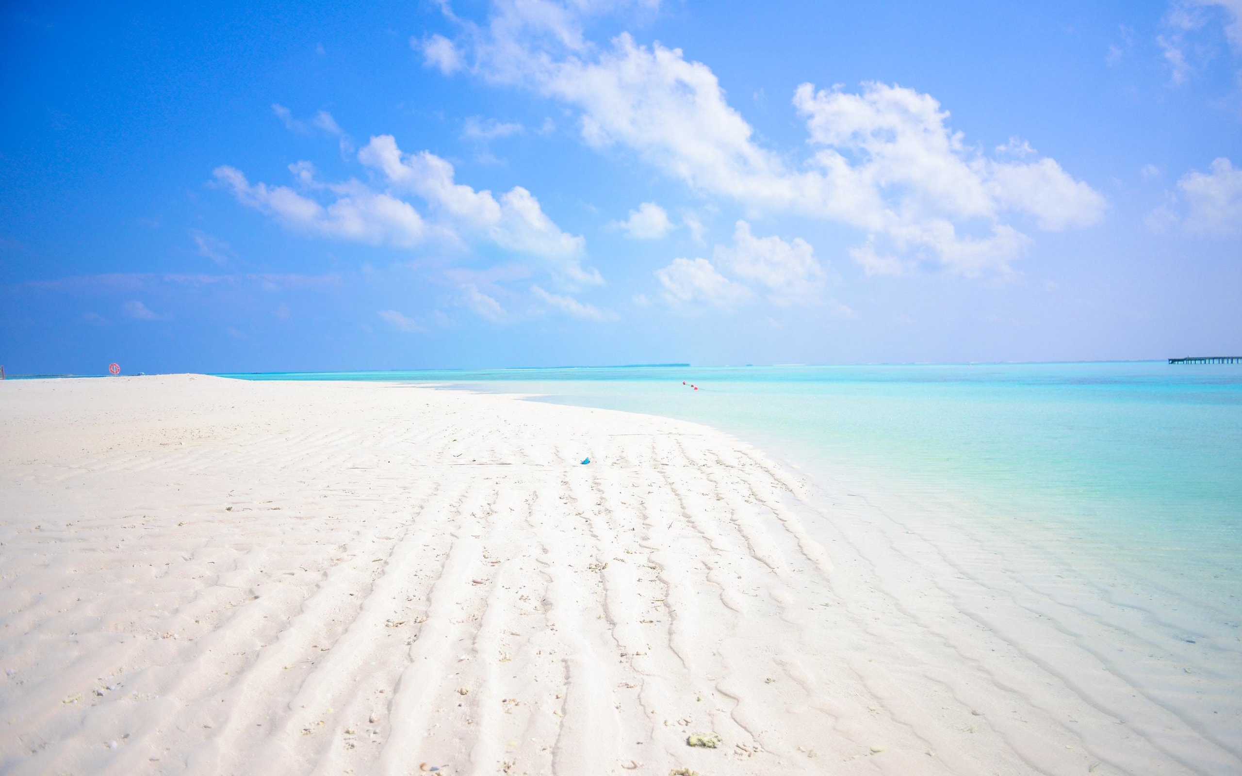 Белый песок на пляже Мальдив под голубым небом