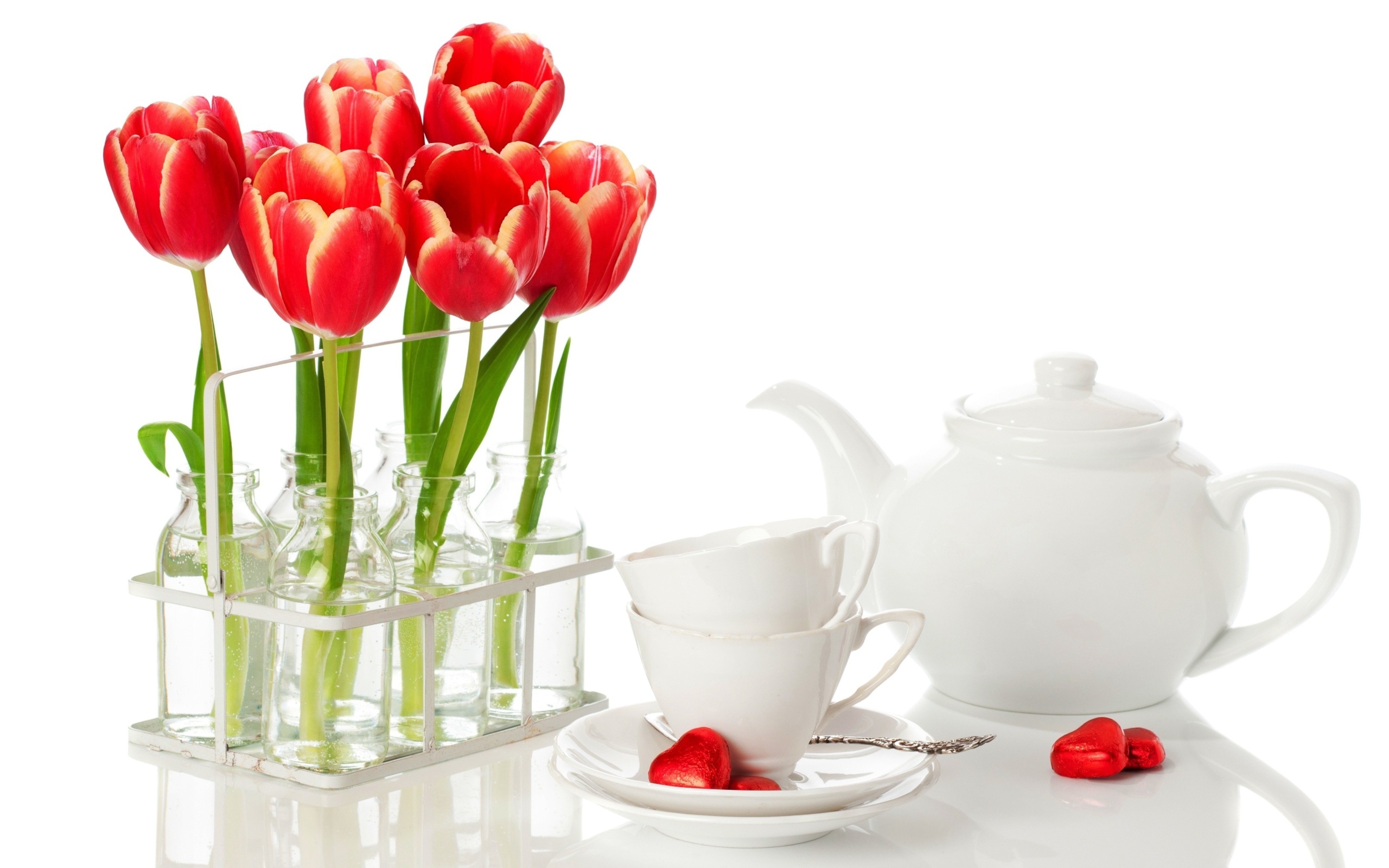 Красные тюльпаны с чайным сервизом на белом фоне