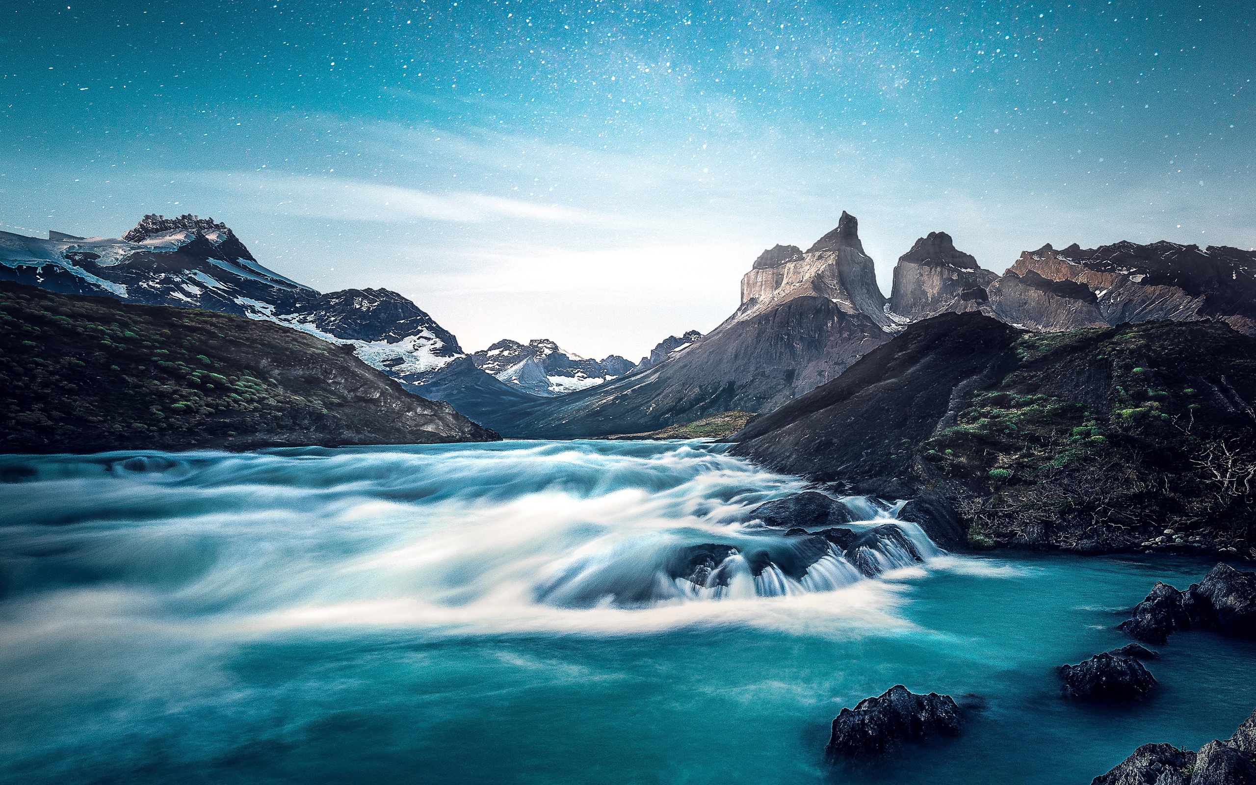 Быстрая вода к реке у гор на фоне голубого неба 