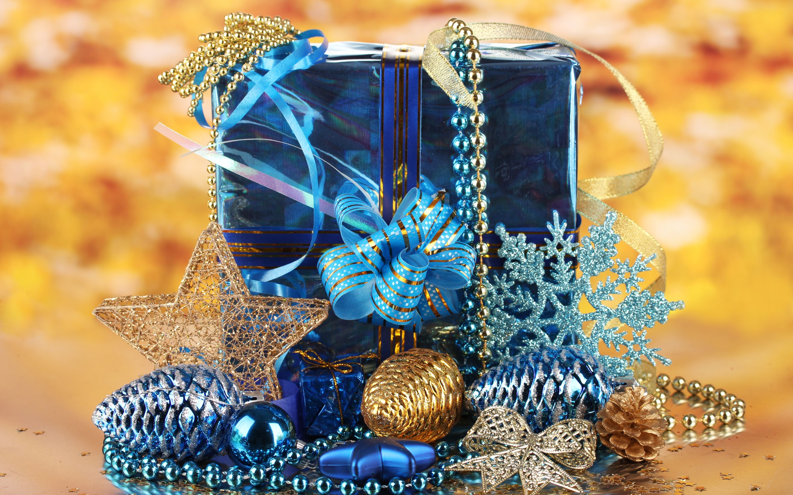 Большой подарок в голубой упаковке с украшениями на Новый год 