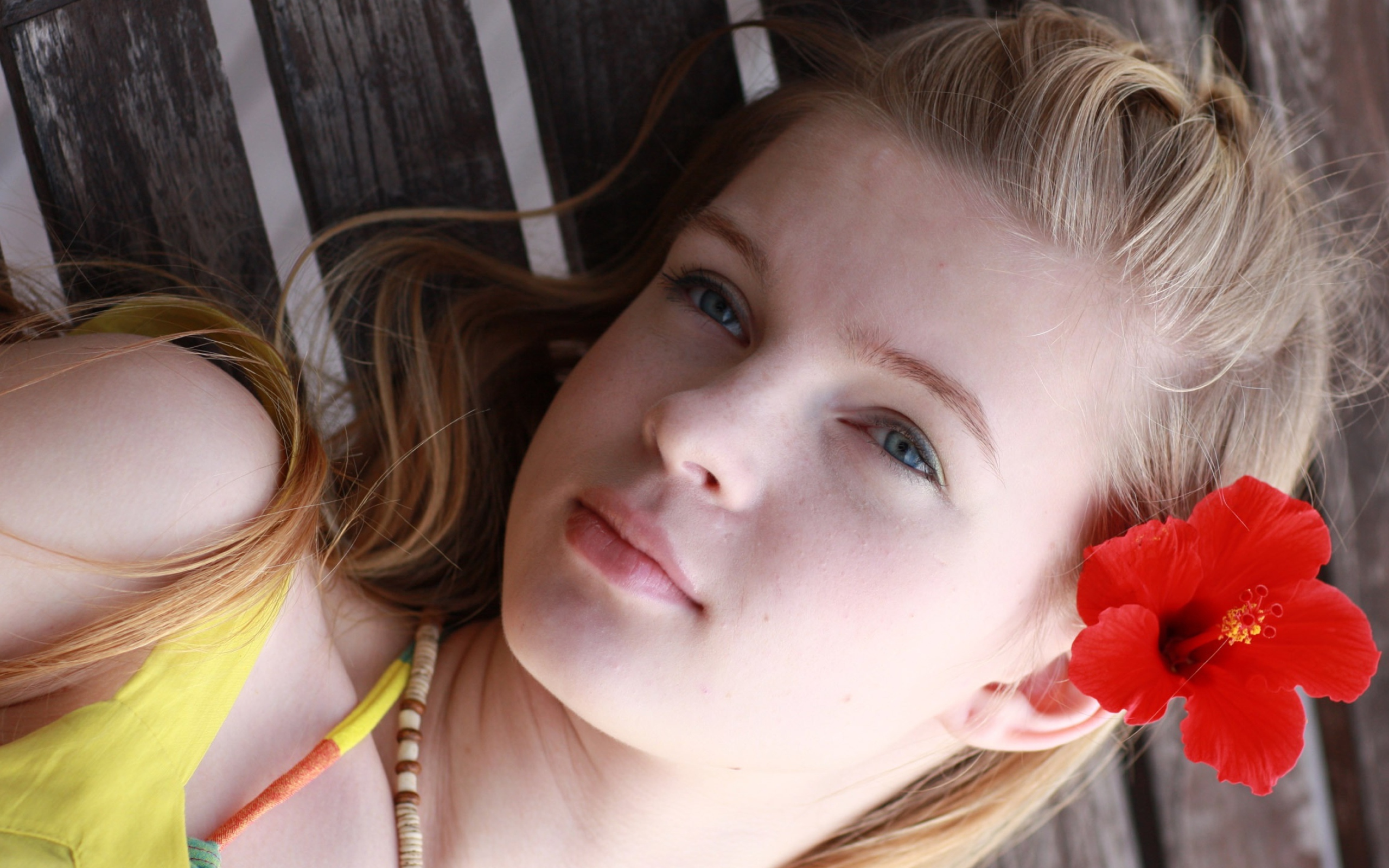 Девочка с красным цветком гибискуса в волосах