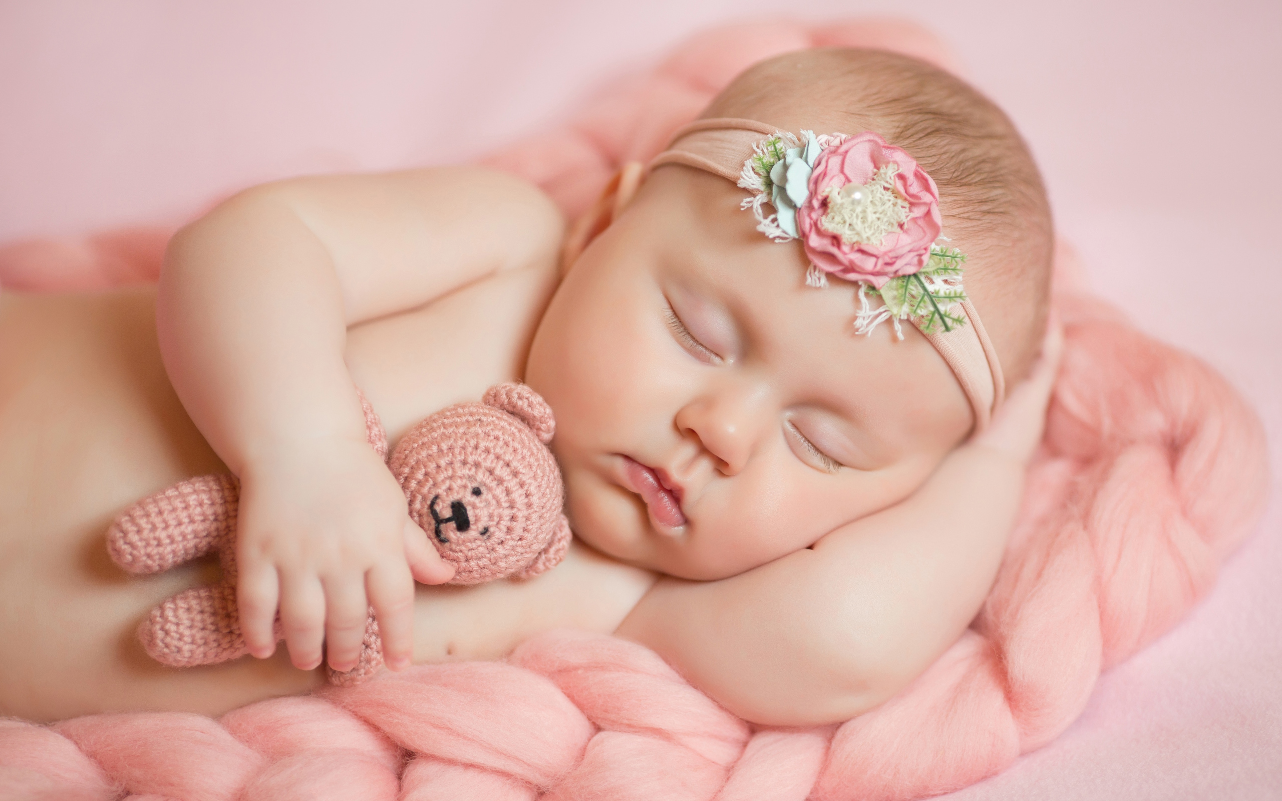 Спящая маленькая девочка с вязаным медвежонком в руке