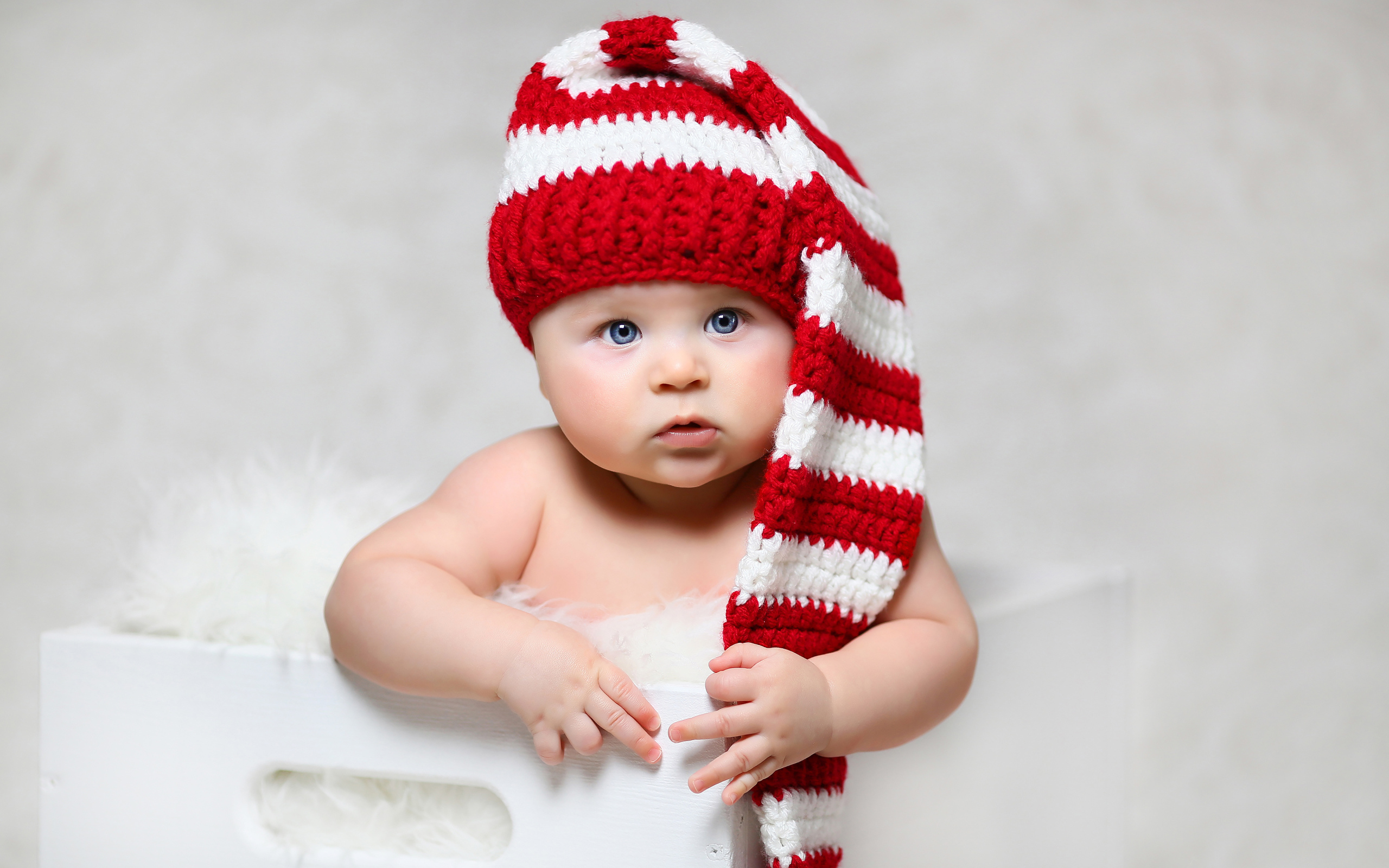 Голубоглазый младенец в длинной вязаной шапке