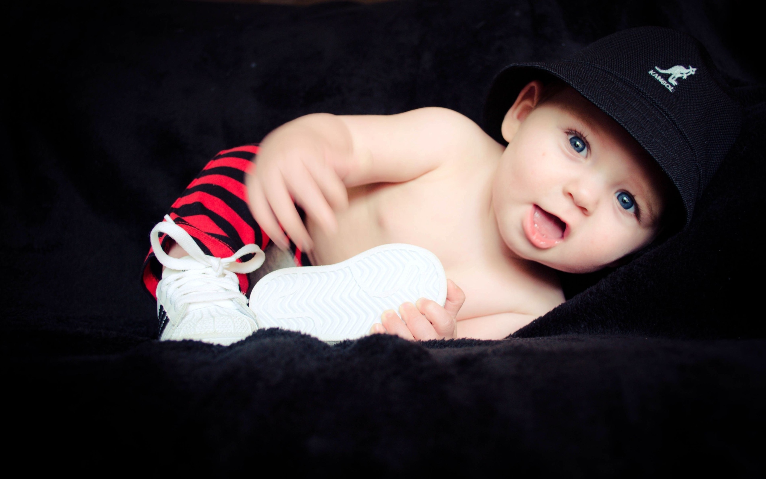 Забавный улыбающийся ребенок в черной панаме