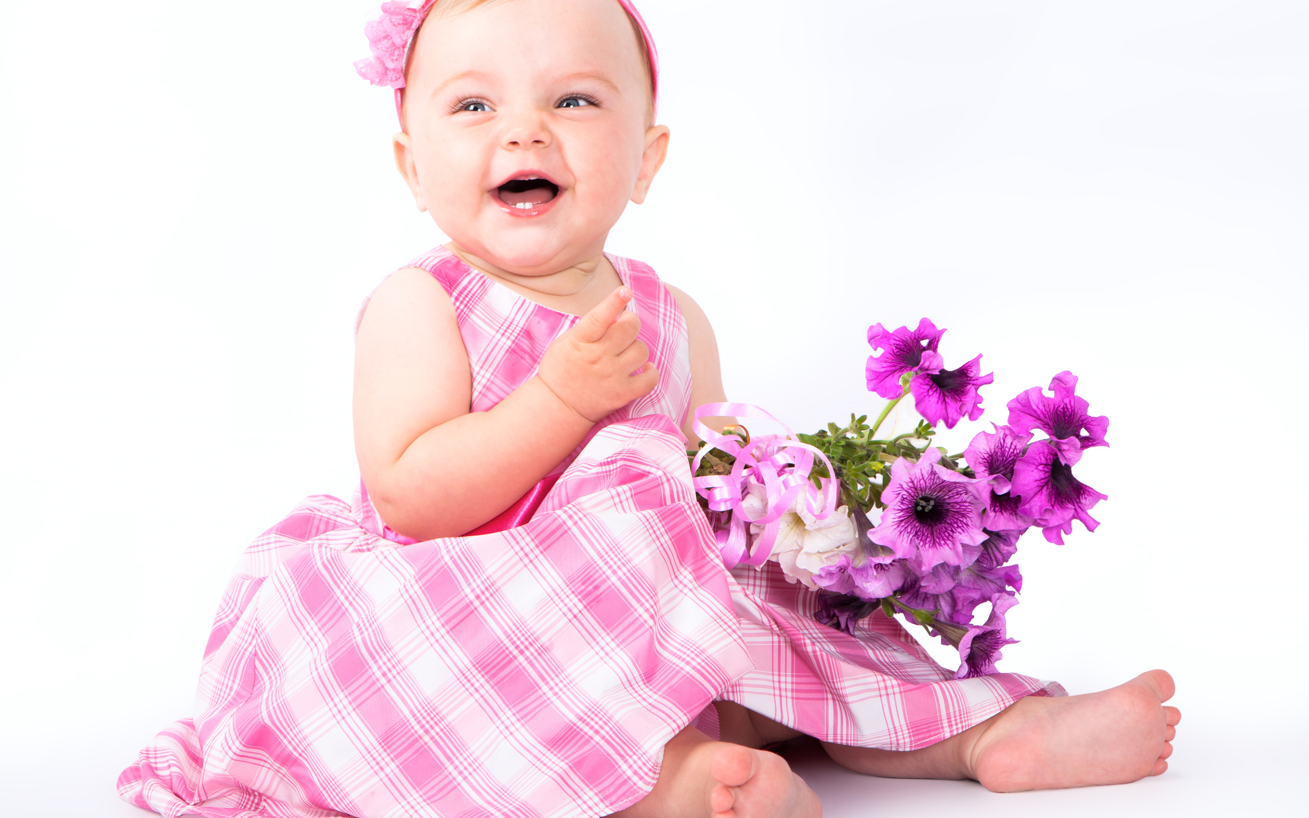 Little smiling girl with a bouquet of petunias on a white background