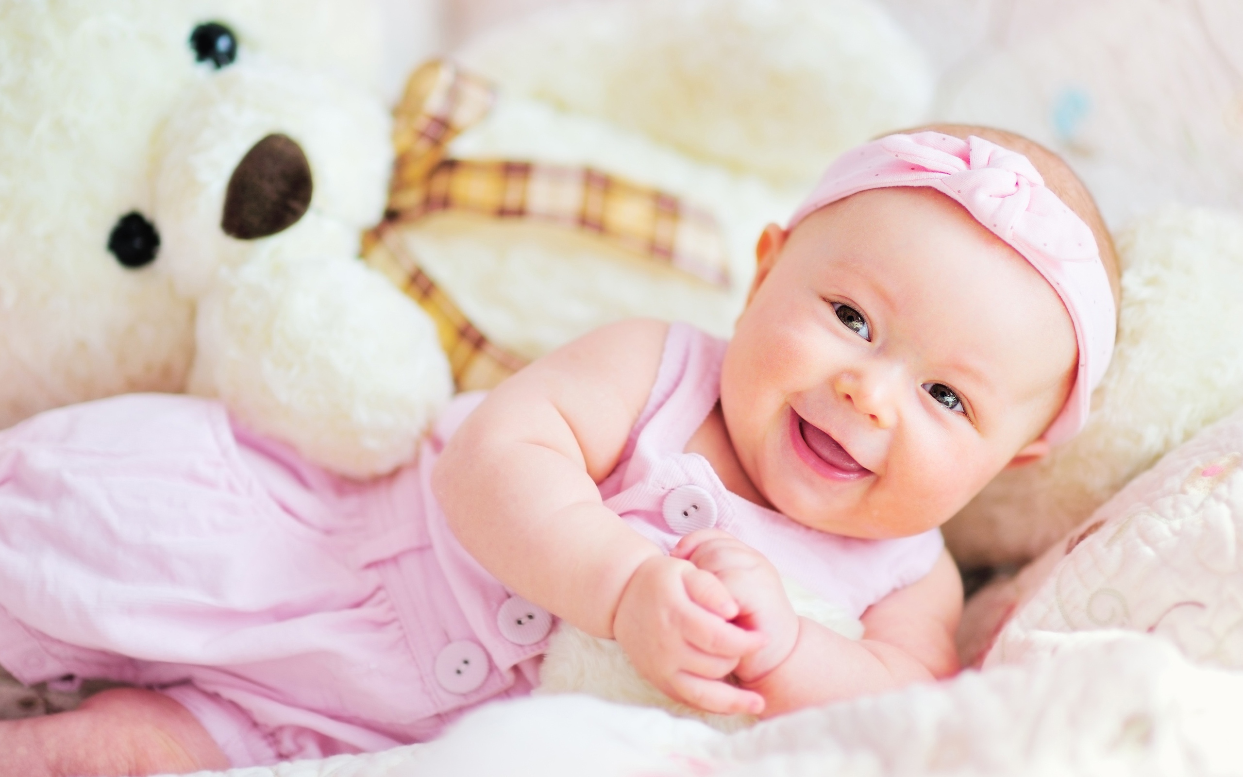 Улыбающаяся маленькая девочка с большим плюшевым медведем