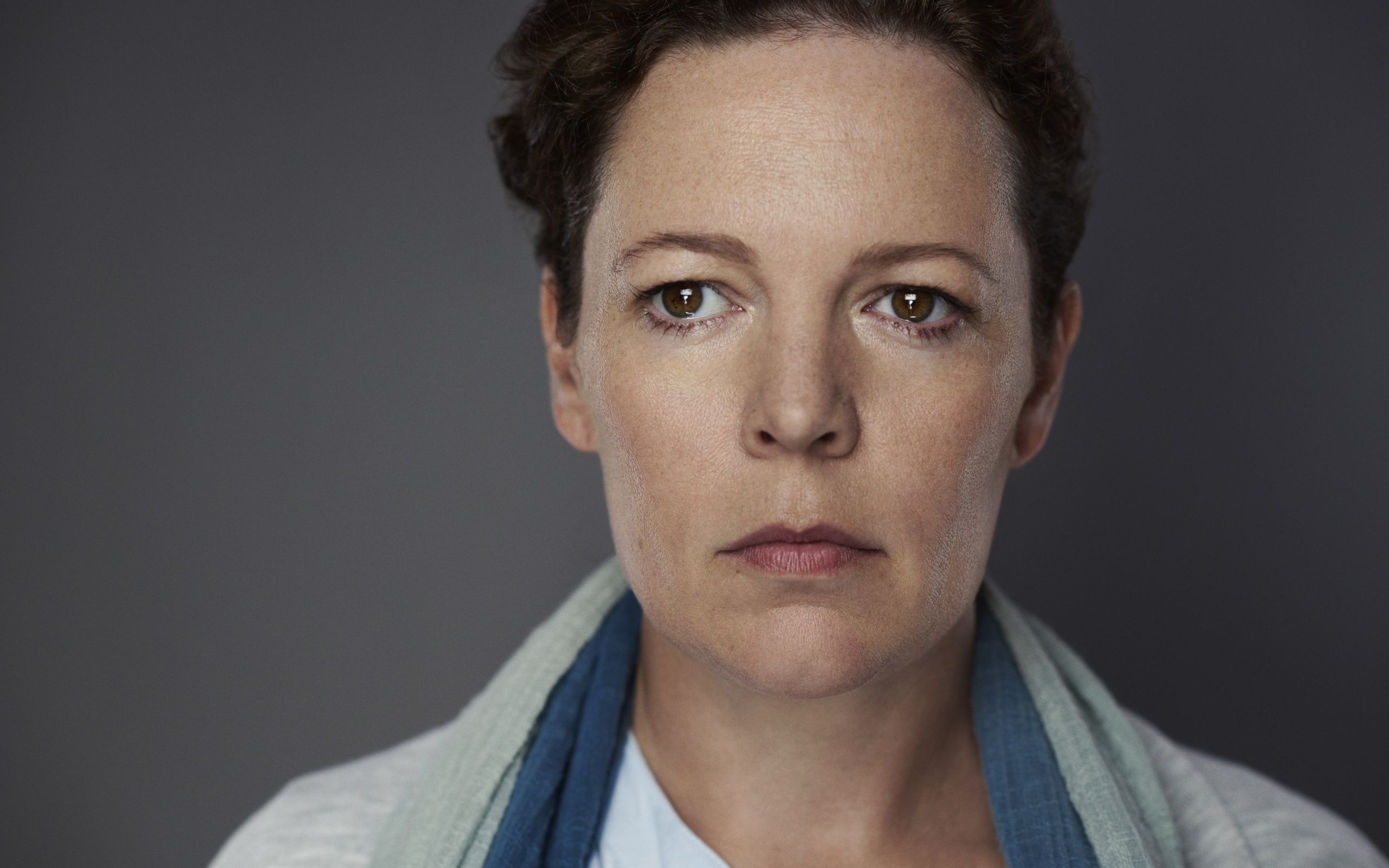 Грустная актриса Оливия Колман на сером фоне