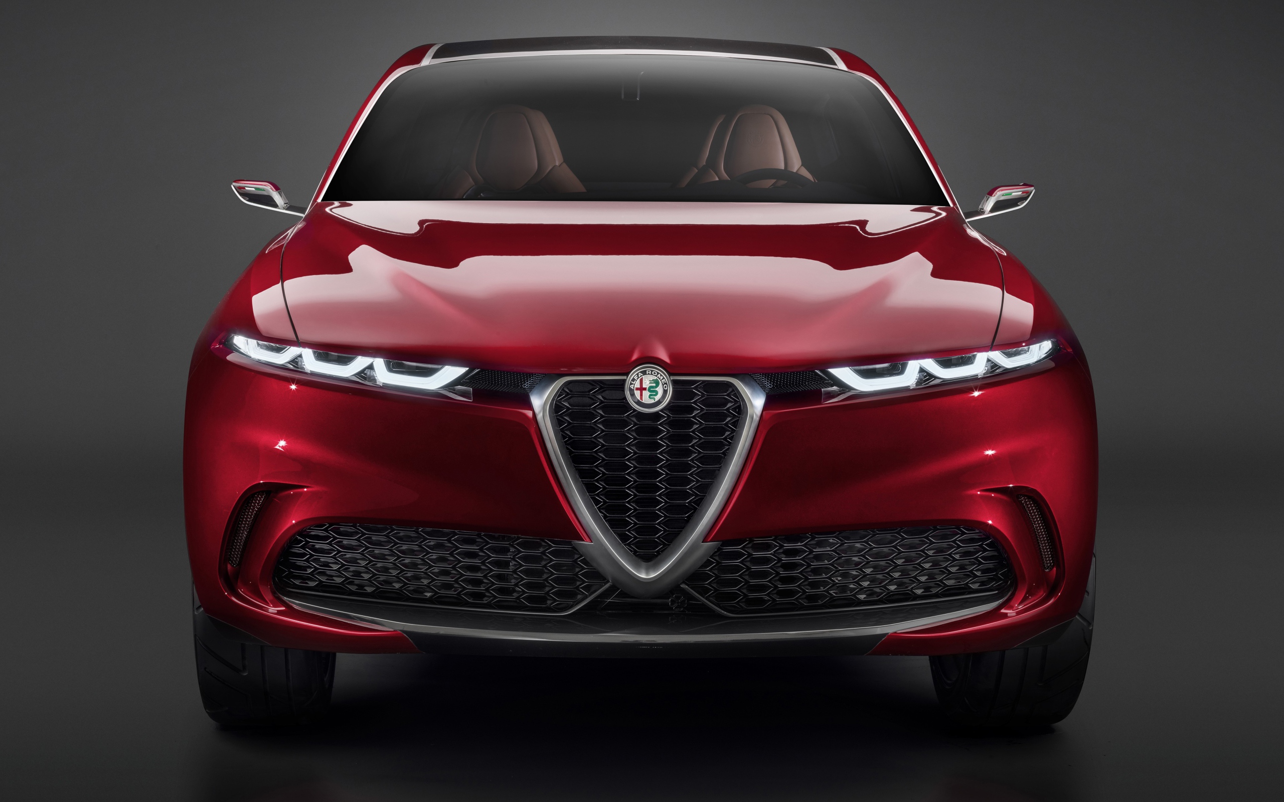Красный автомобиль Alfa Romeo Tonale Concept,  2019 года вид спереди на сером фоне