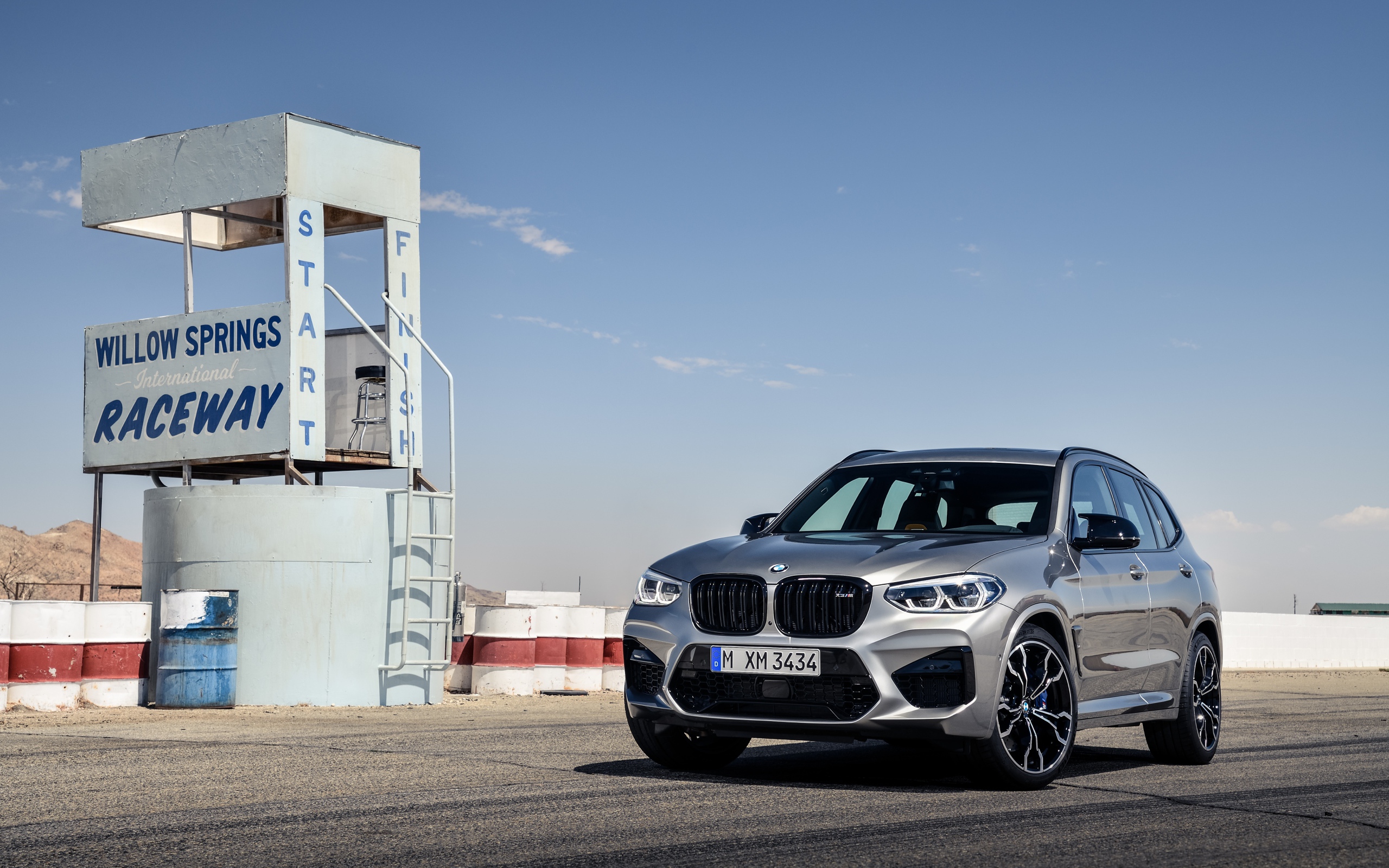 Серебристый автомобиль BMW X3 на асфальте