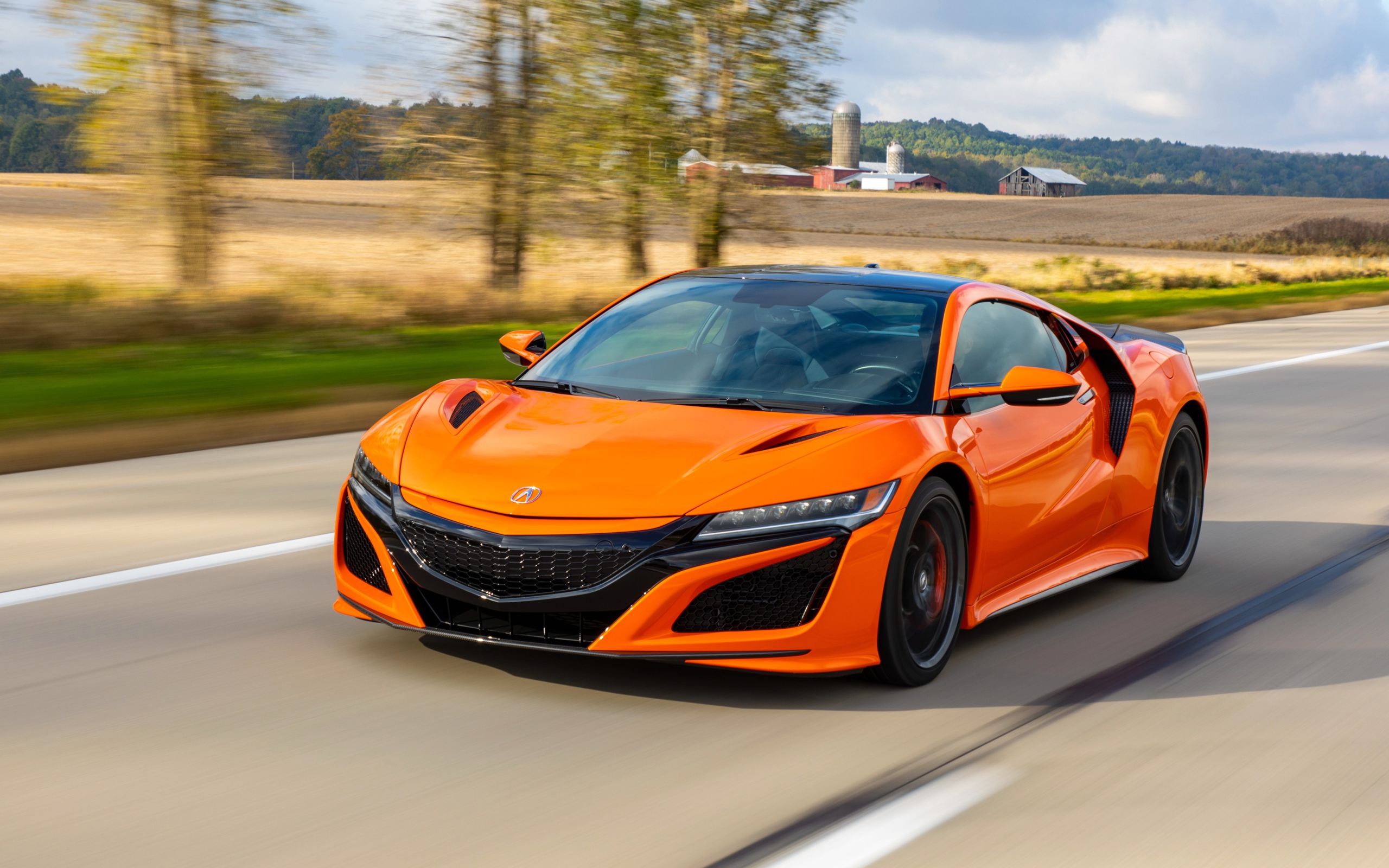 Оранжевый автомобиль Honda NSX на трассе