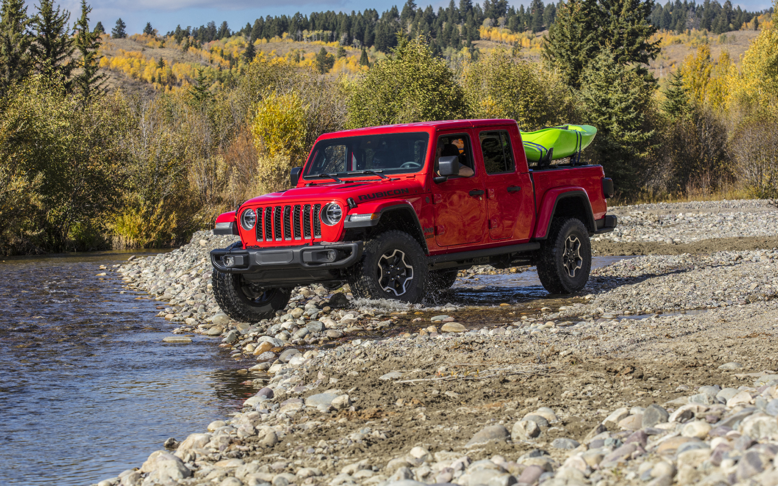 Красный пикап Jeep Gladiator Rubicon, 2020 года у реки
