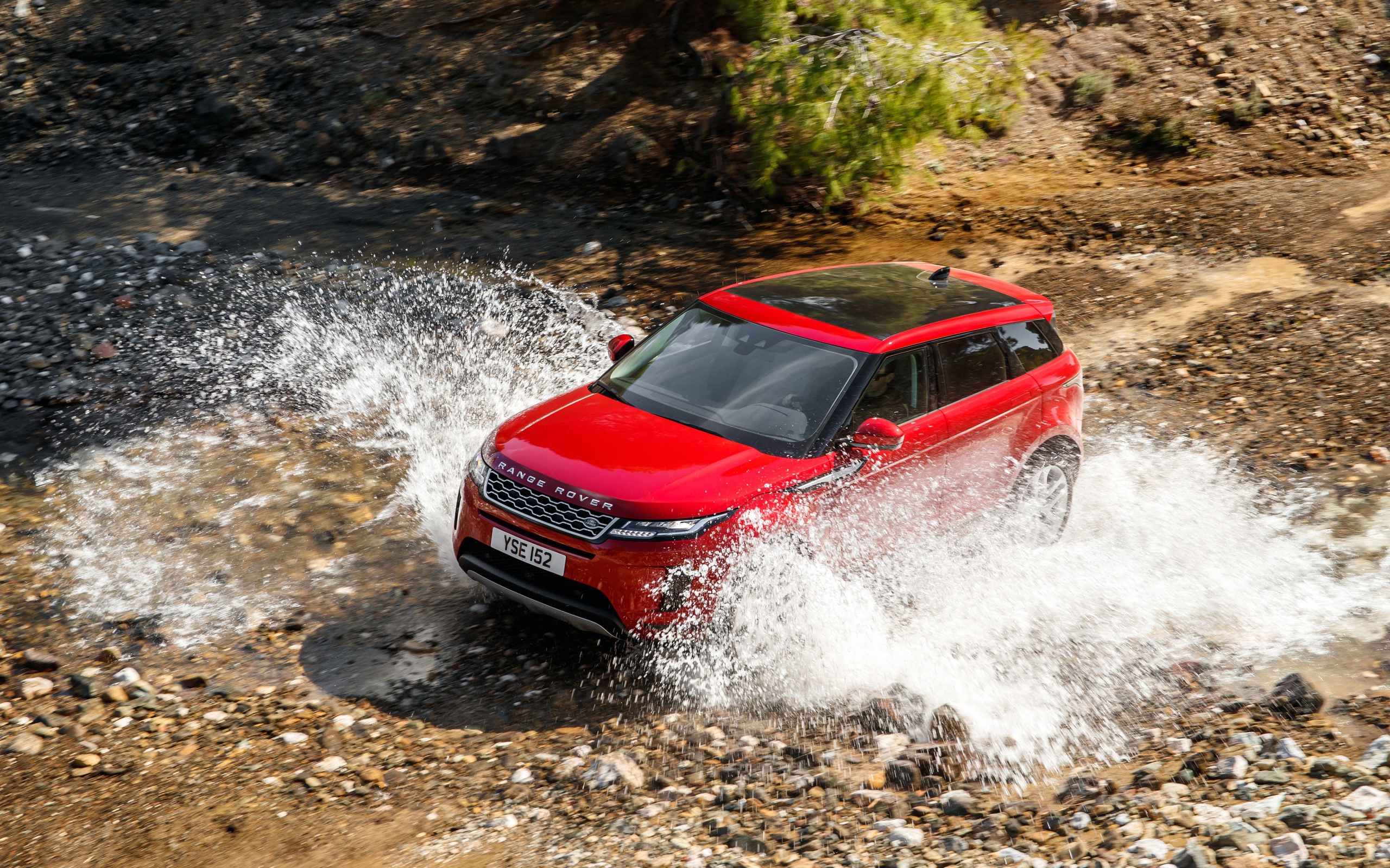 Красный внедорожник Range Rover Evoque D240 S 2019 года едет по воде