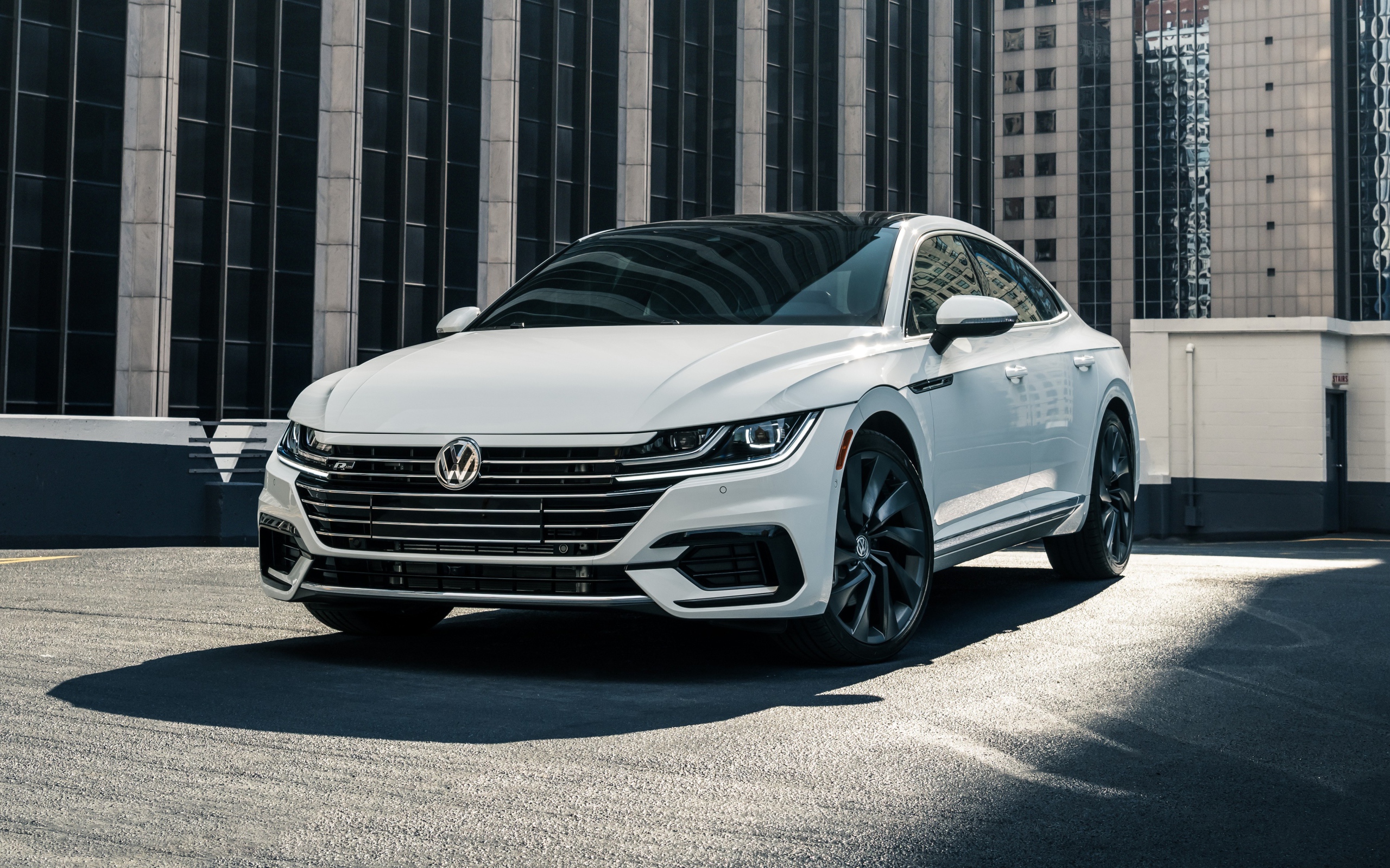 Белый автомобиль Volkswagen Arteon, 2019 года у здания 