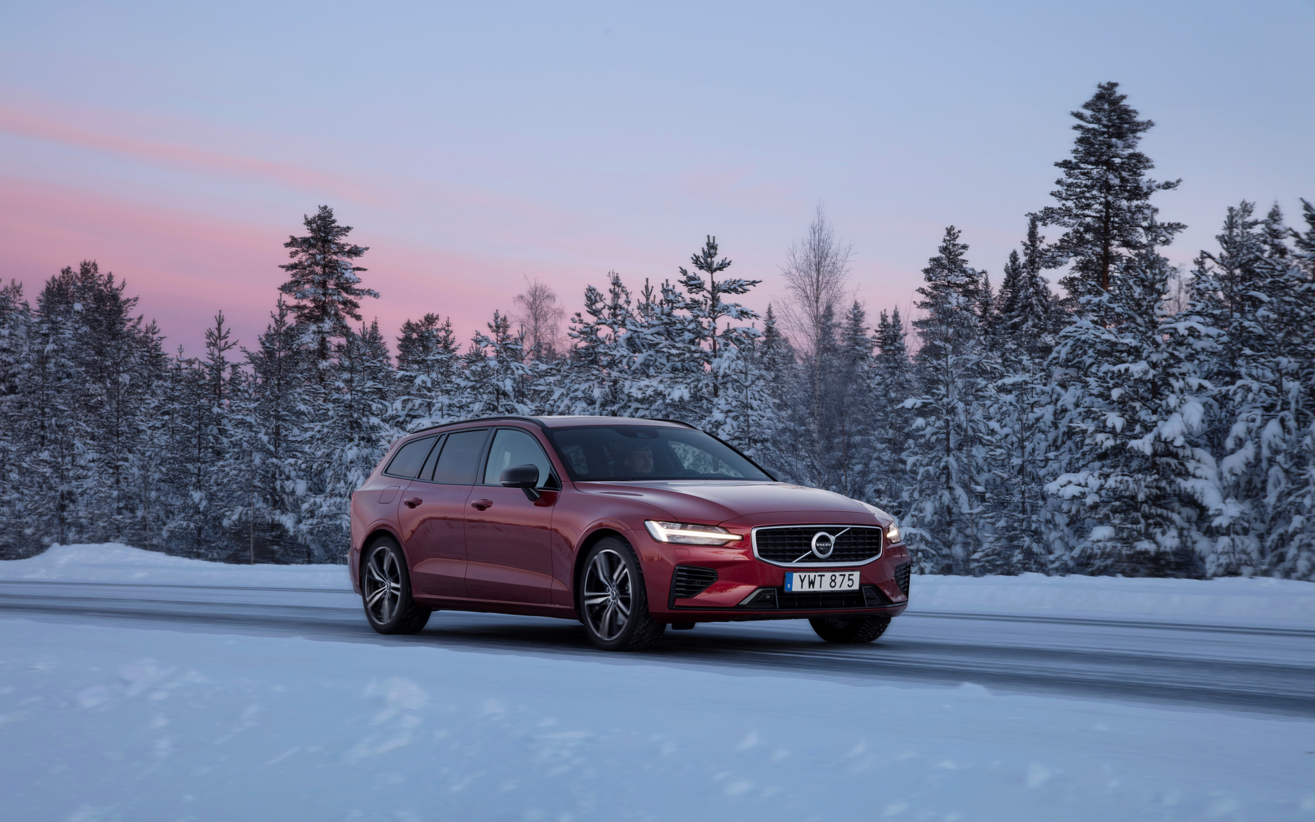 Красный автомобиль Volvo V60 на зимней дороге