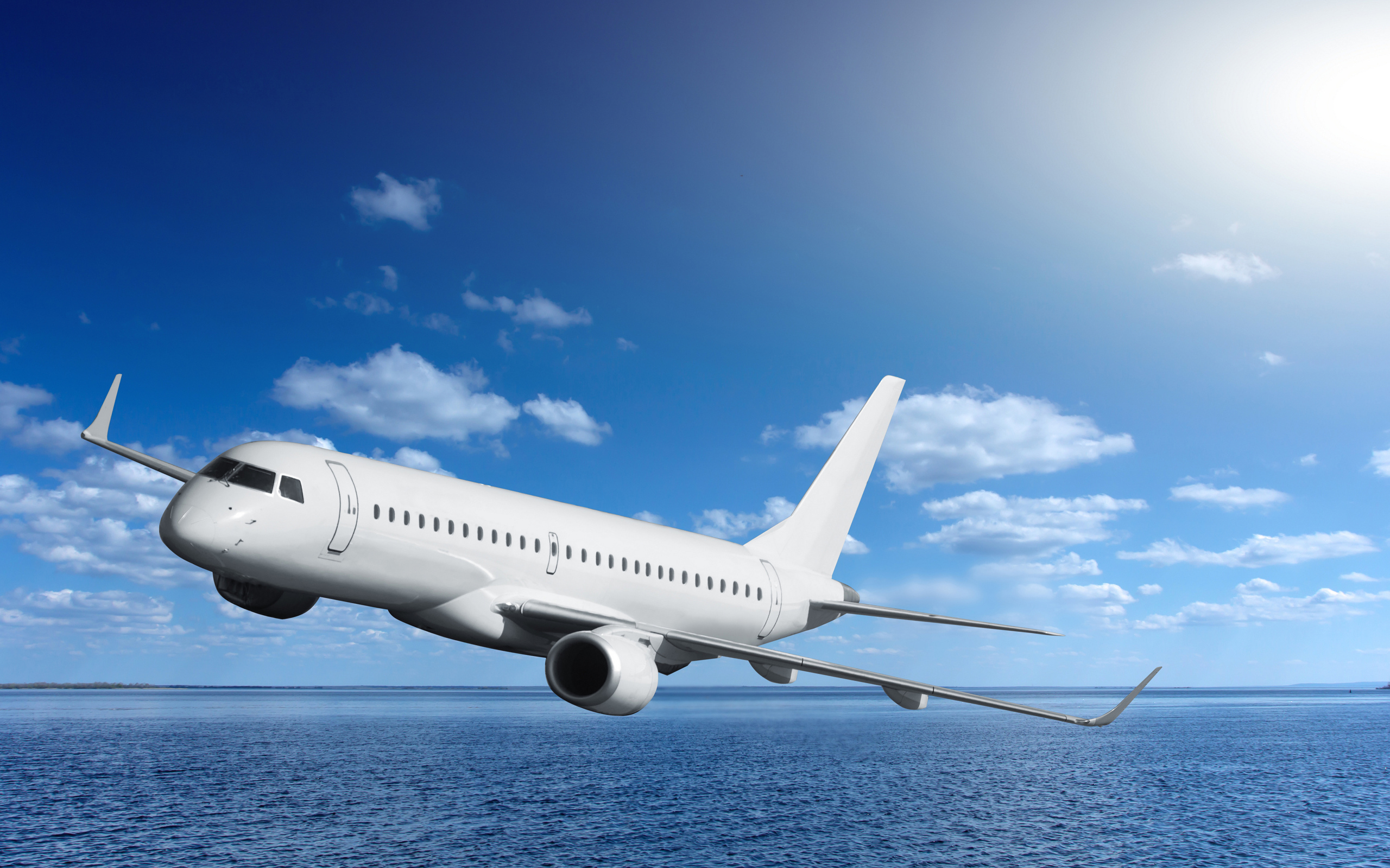 Большой белый пассажирский самолет летит над морем