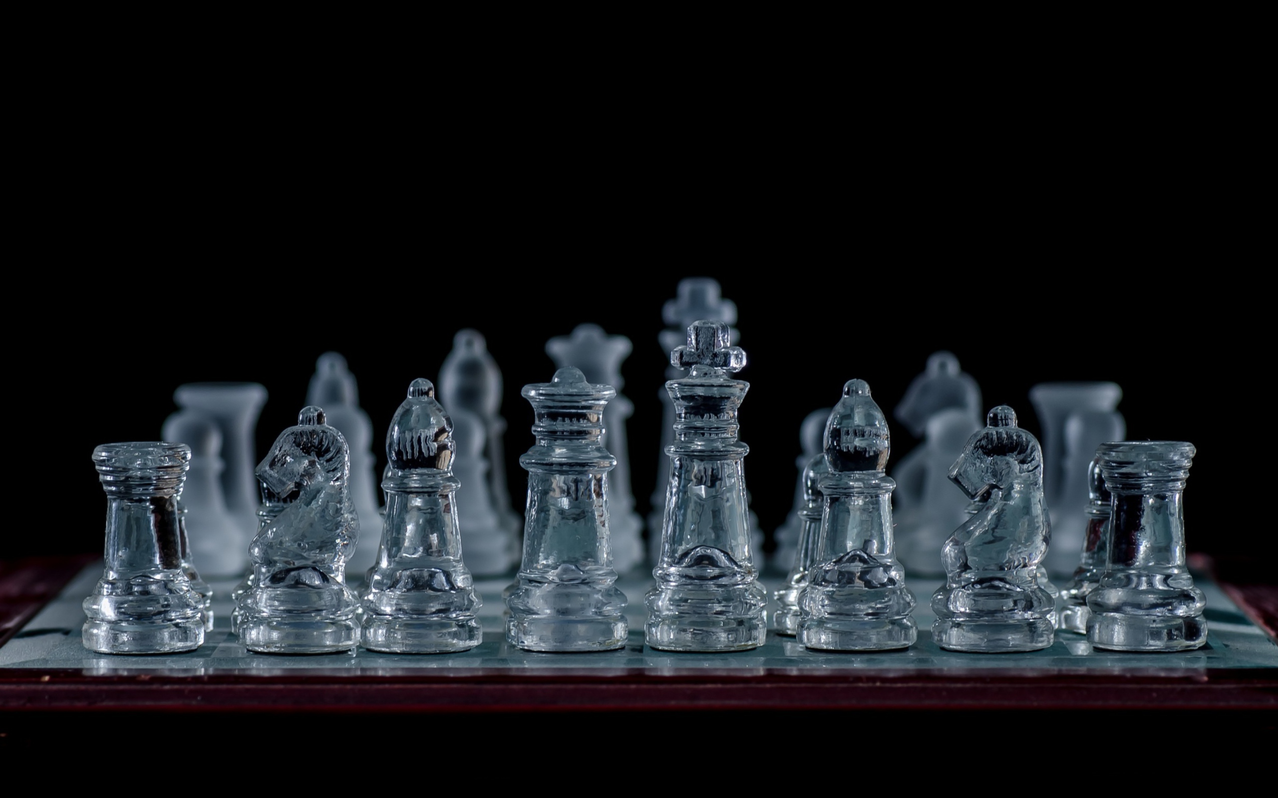 Glass chess on a chessboard on a black background