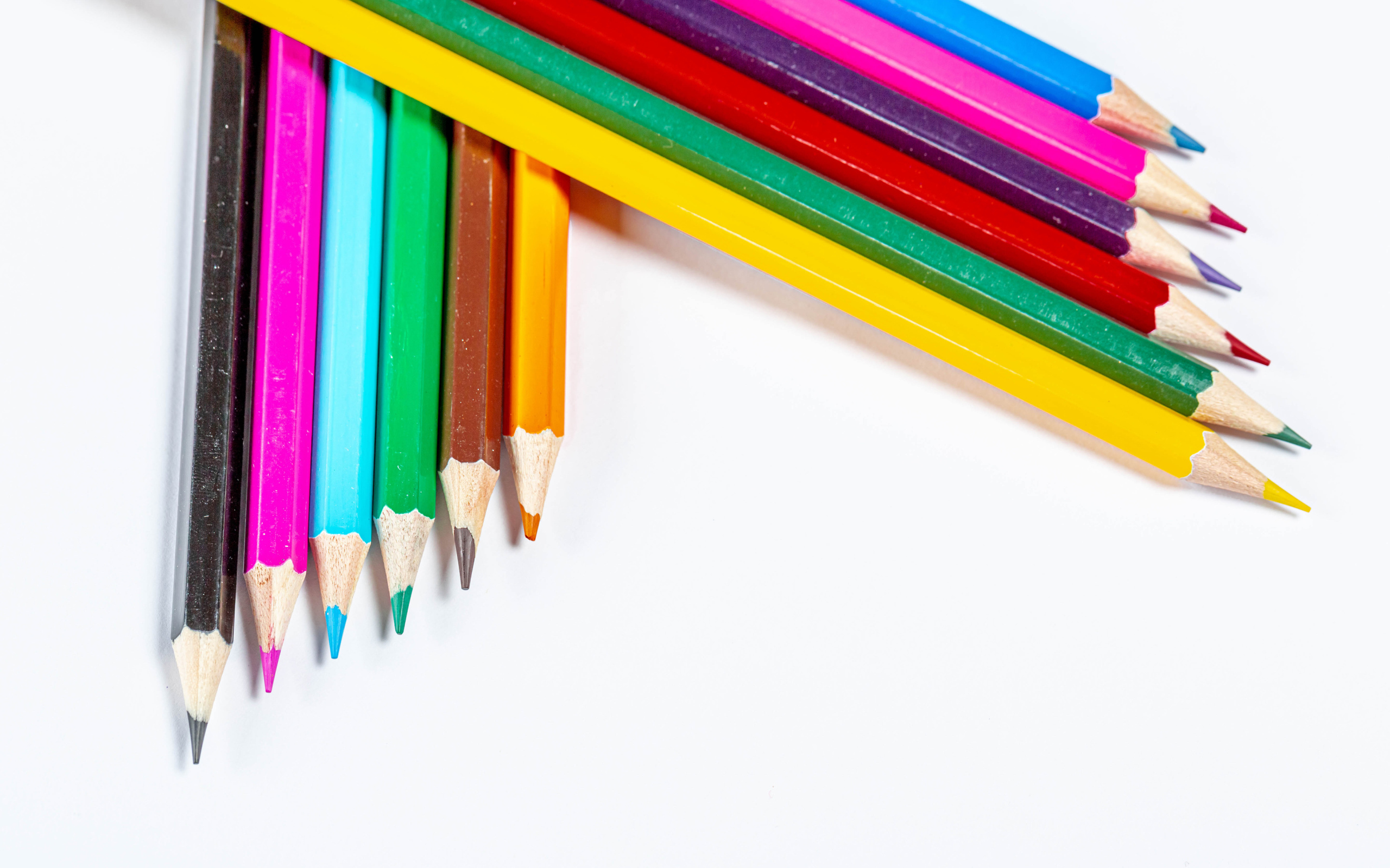 Разноцветные острые карандаши на белом фоне