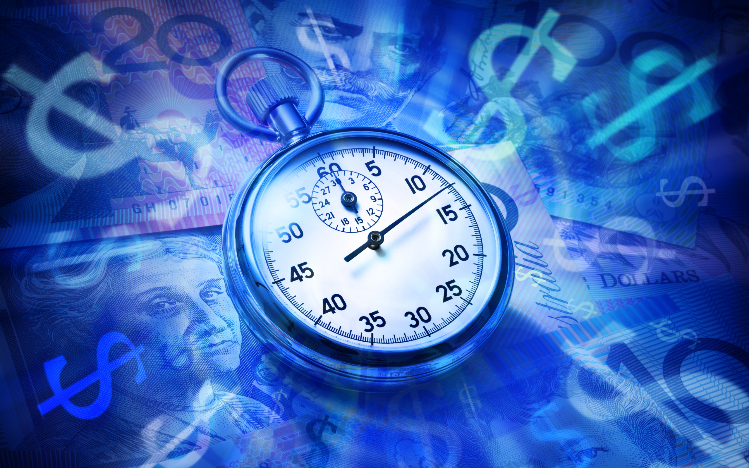 Секундомер лежит на купюрах разных стран 