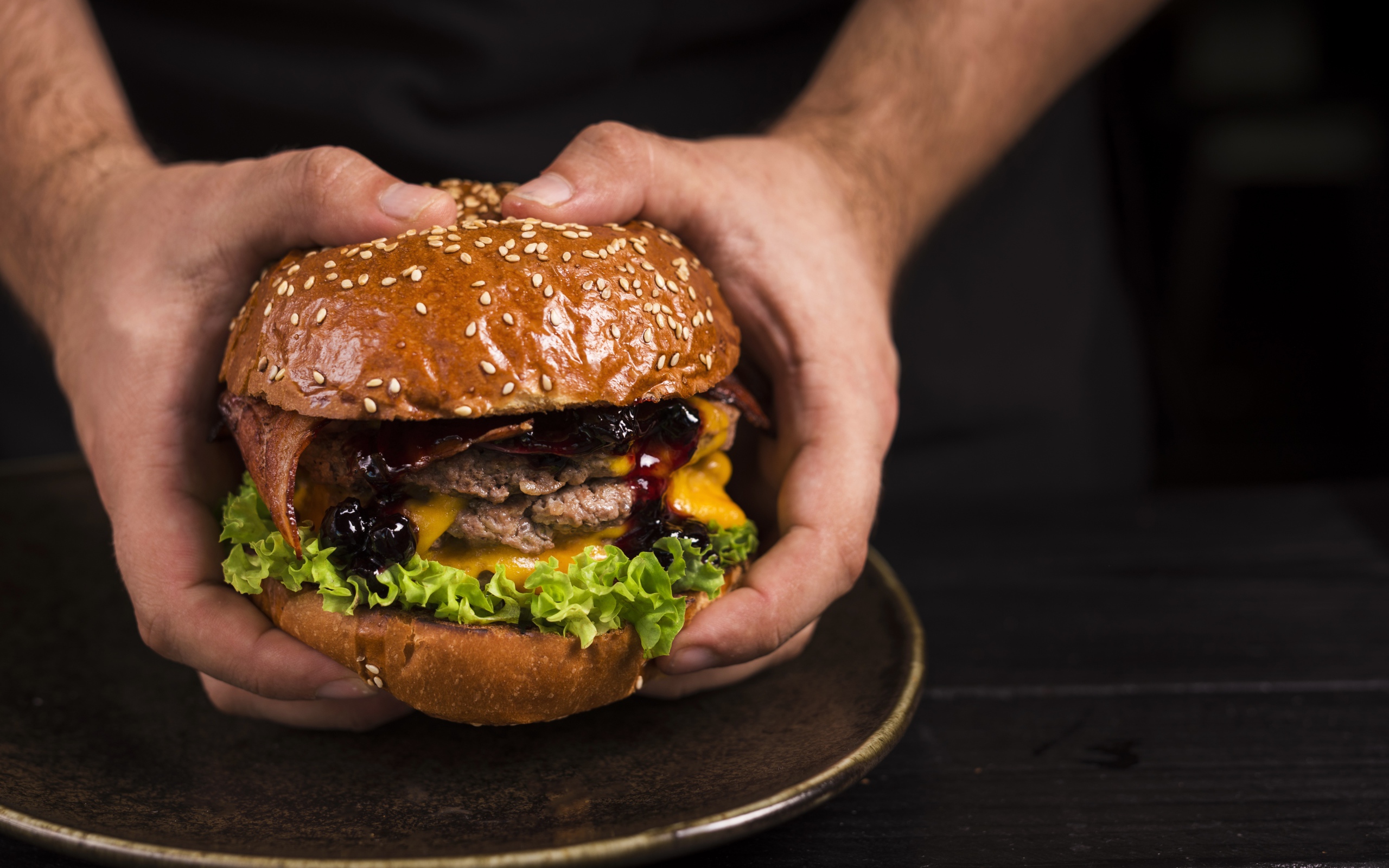 Большой сочный гамбургер в руках