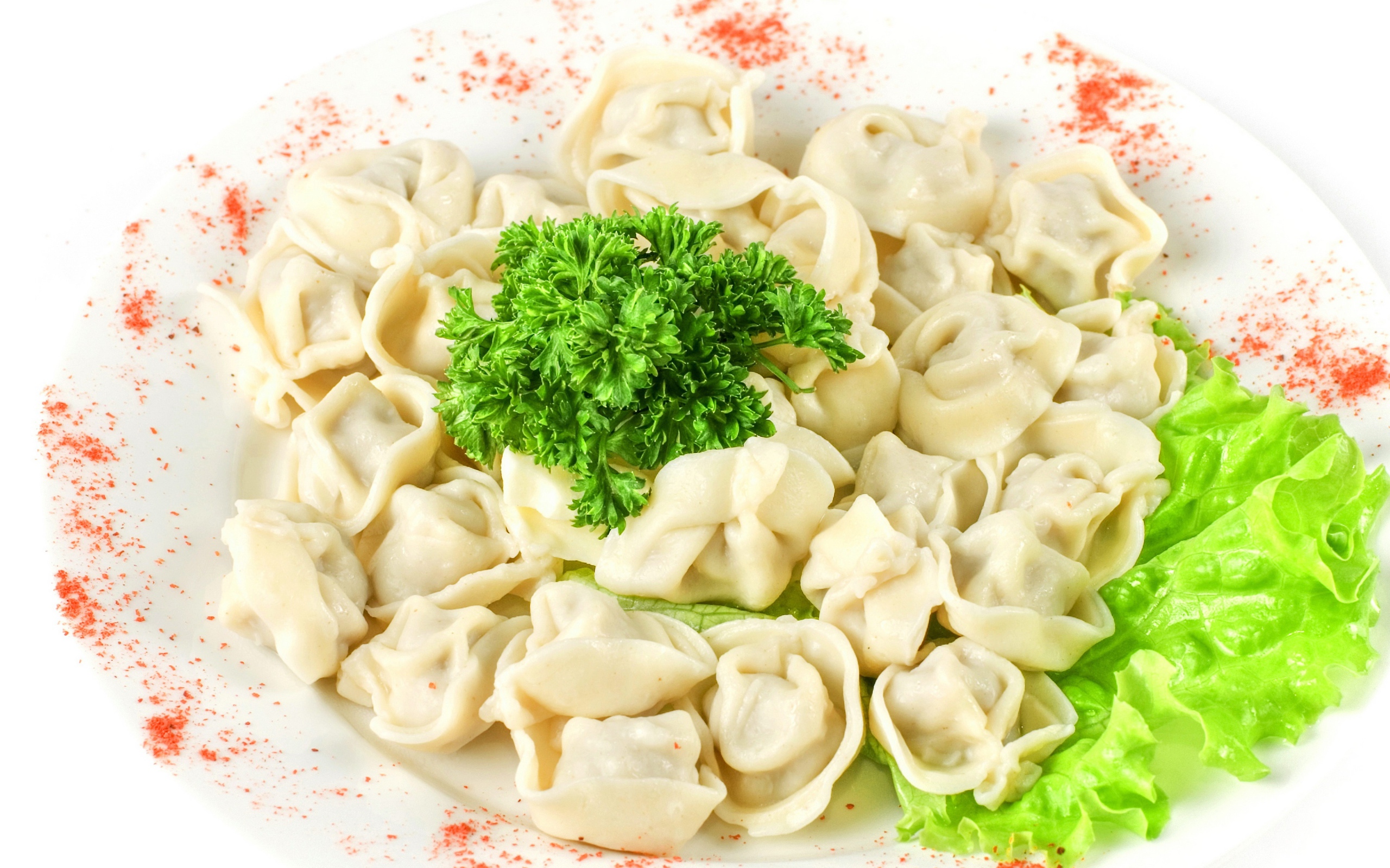 Dumplings with parsley and lettuce on a chili with red pepper